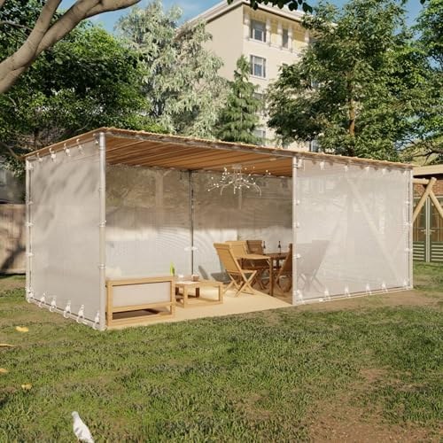 Open air sukkah with mesh walls on a lawn, set with a table and chairs