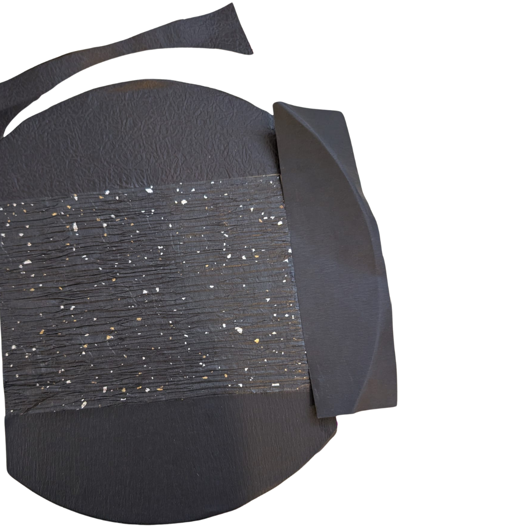 Torn black textured papers covering the rest of the wooden circle
