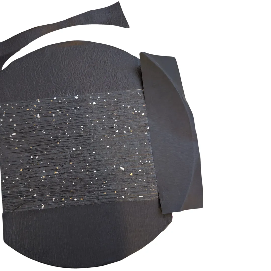 Torn black textured papers covering the rest of the wooden circle