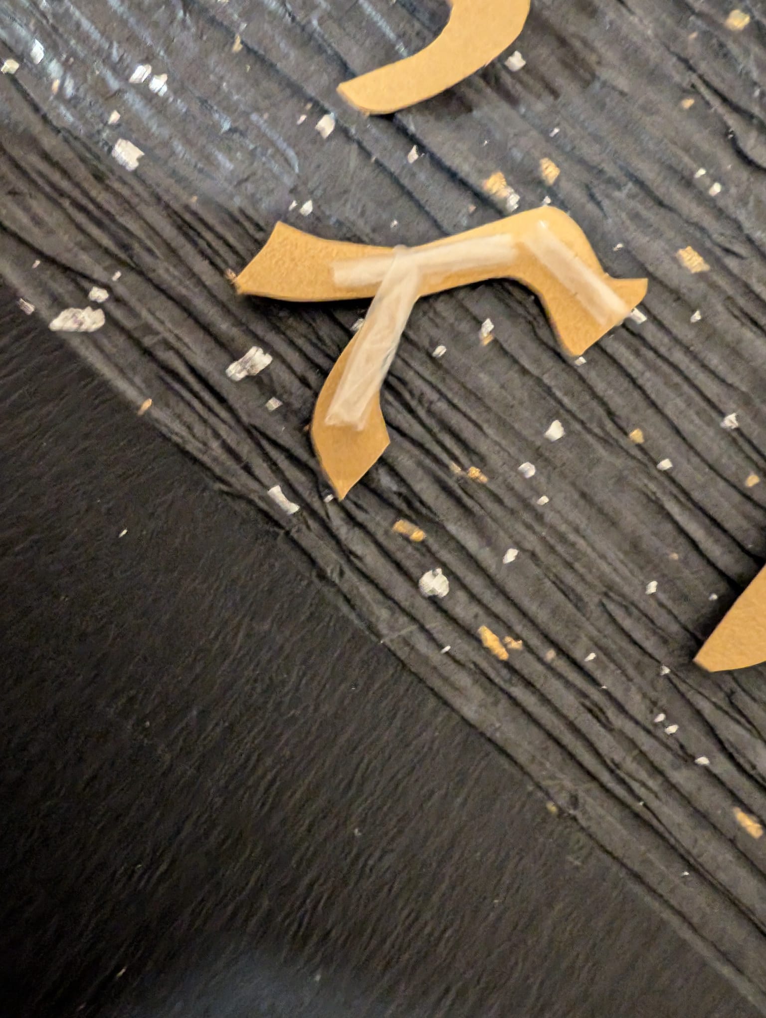 Gold Hebrew letters being pressed onto the black circle