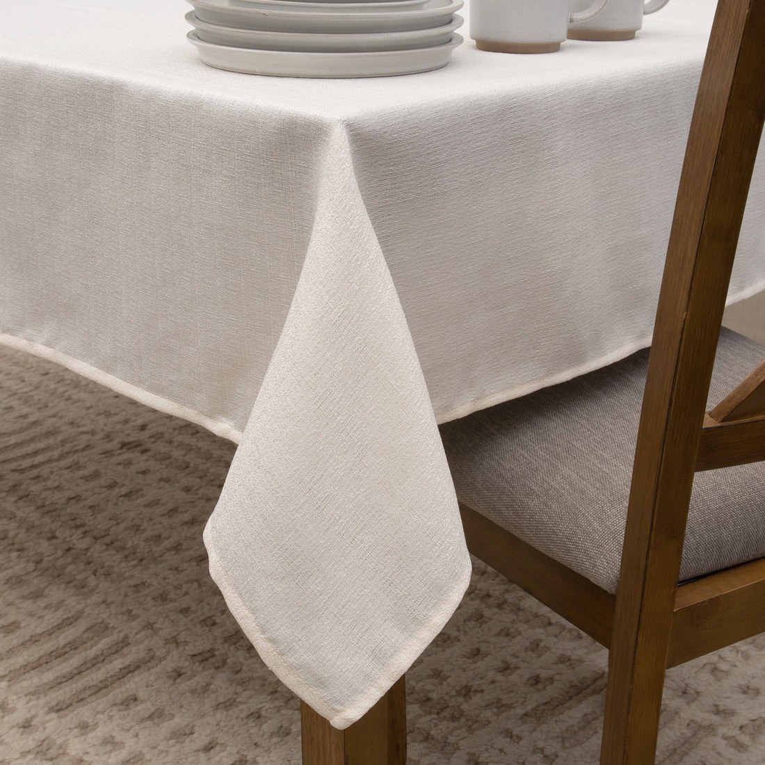 Plain waterproof linen-look tablecloth draped over a dining table