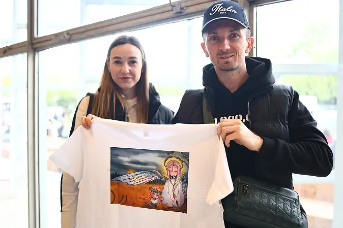 Учасники виставки тримають футболку з малюнком Назара.