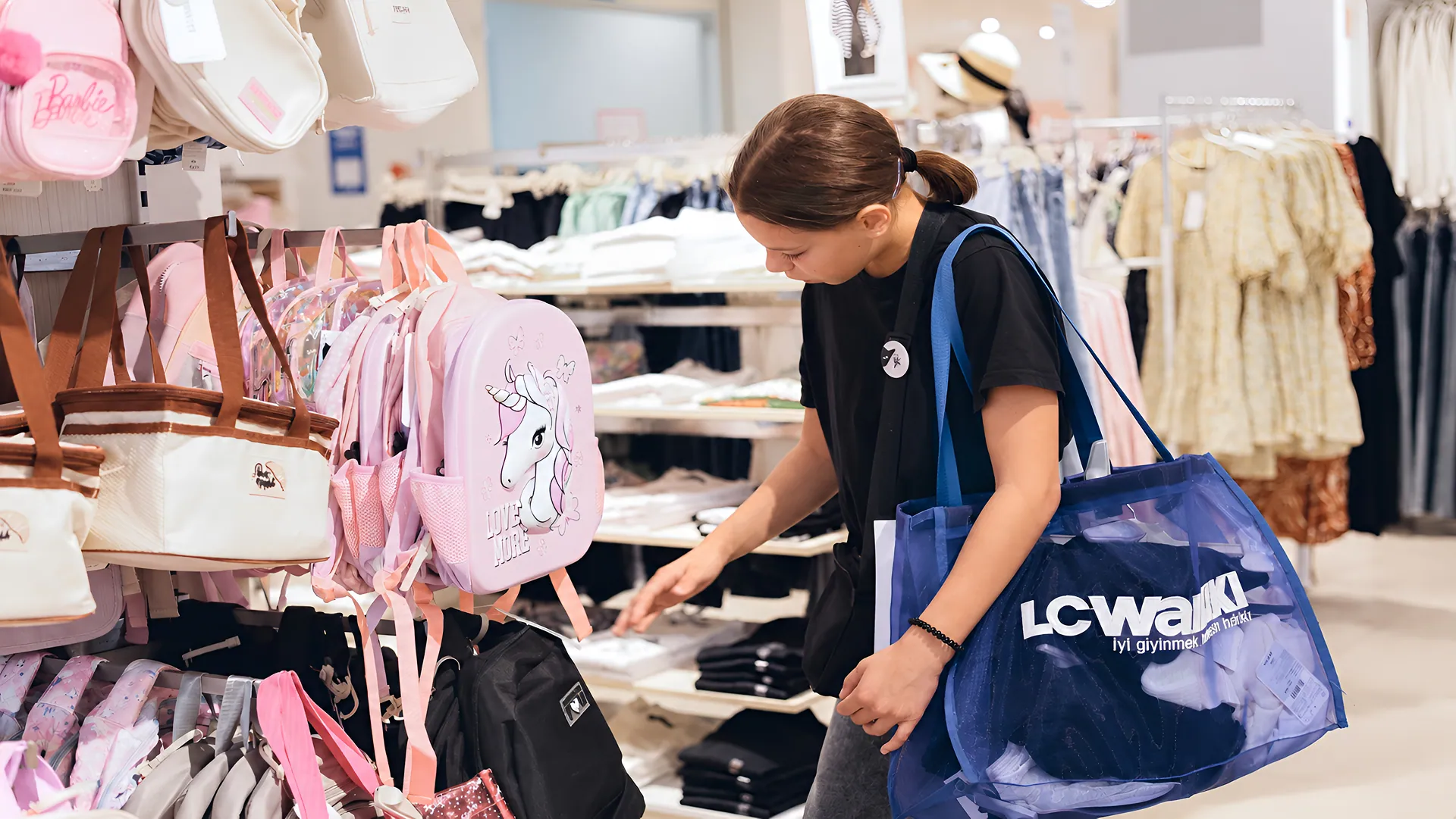 A girl chooses clothes during a shopping trip as part of the Back to School Drive project.
