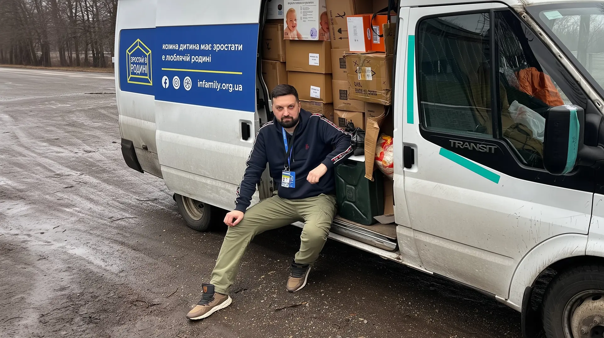Представник фонду біля автомобіля, завантаженого коробками з допомогою