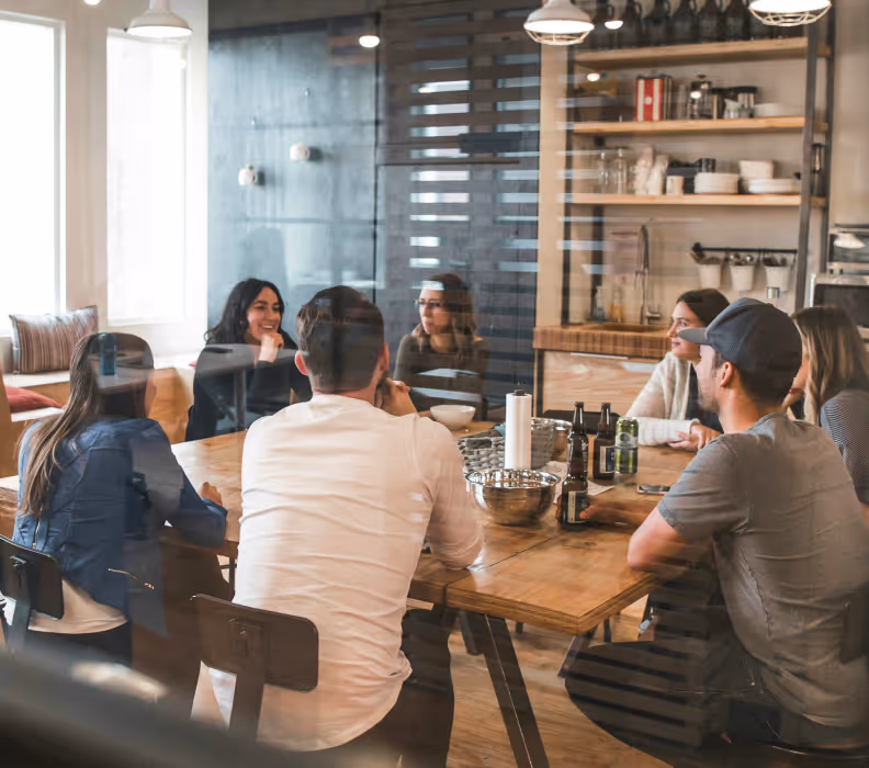 Casually dressed team sitting around rustic  table