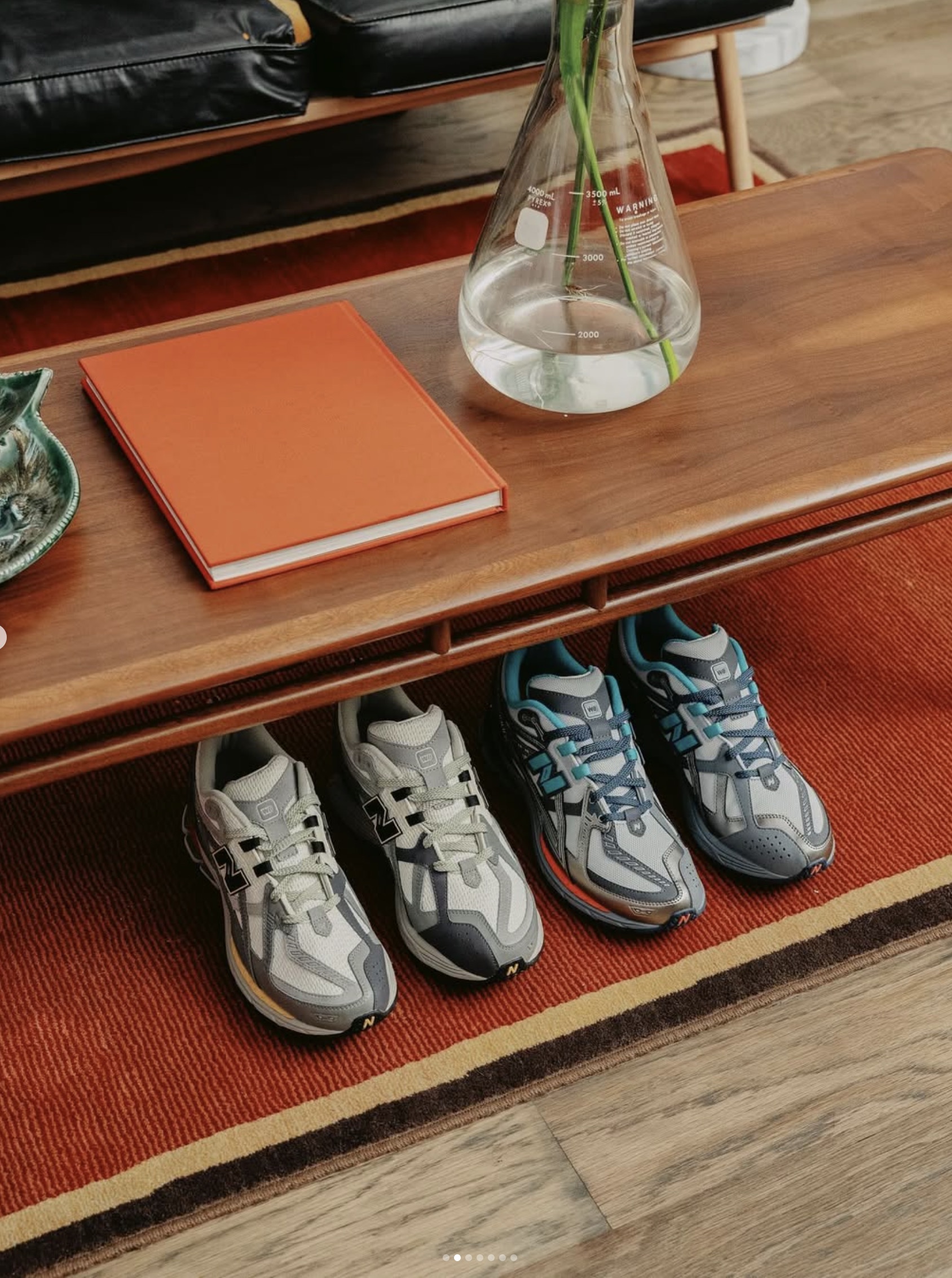 new balance shoes sitting under a coffee table