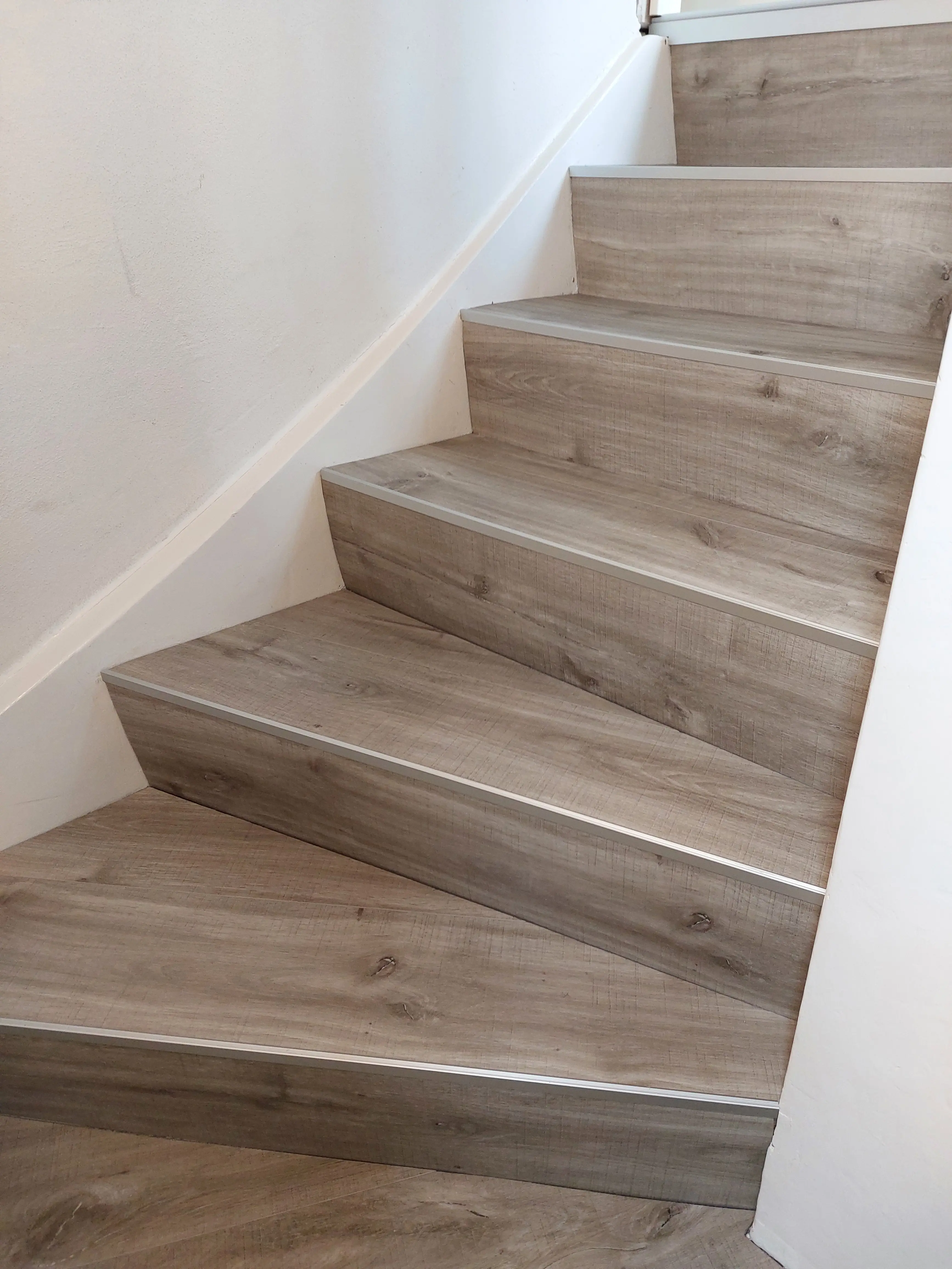 Geradlinige Treppe mit moderner Vinyl-Neubelegung in heller Holzoptik in Viernheim