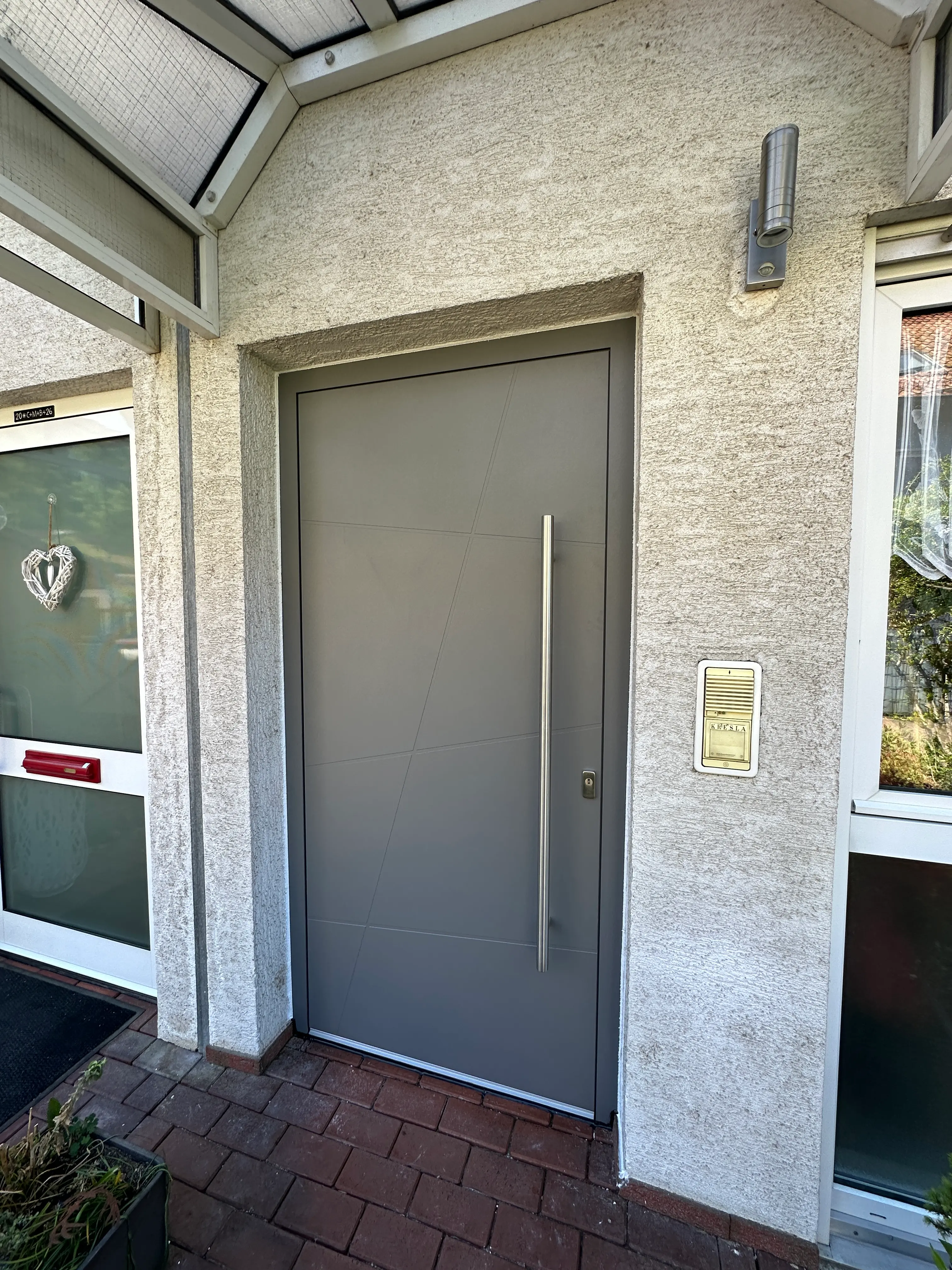 Moderne anthrazitfarbene Aluminiumhaustür mit Edelstahlgriff nach der Haustürmodernisierung in Viernheim