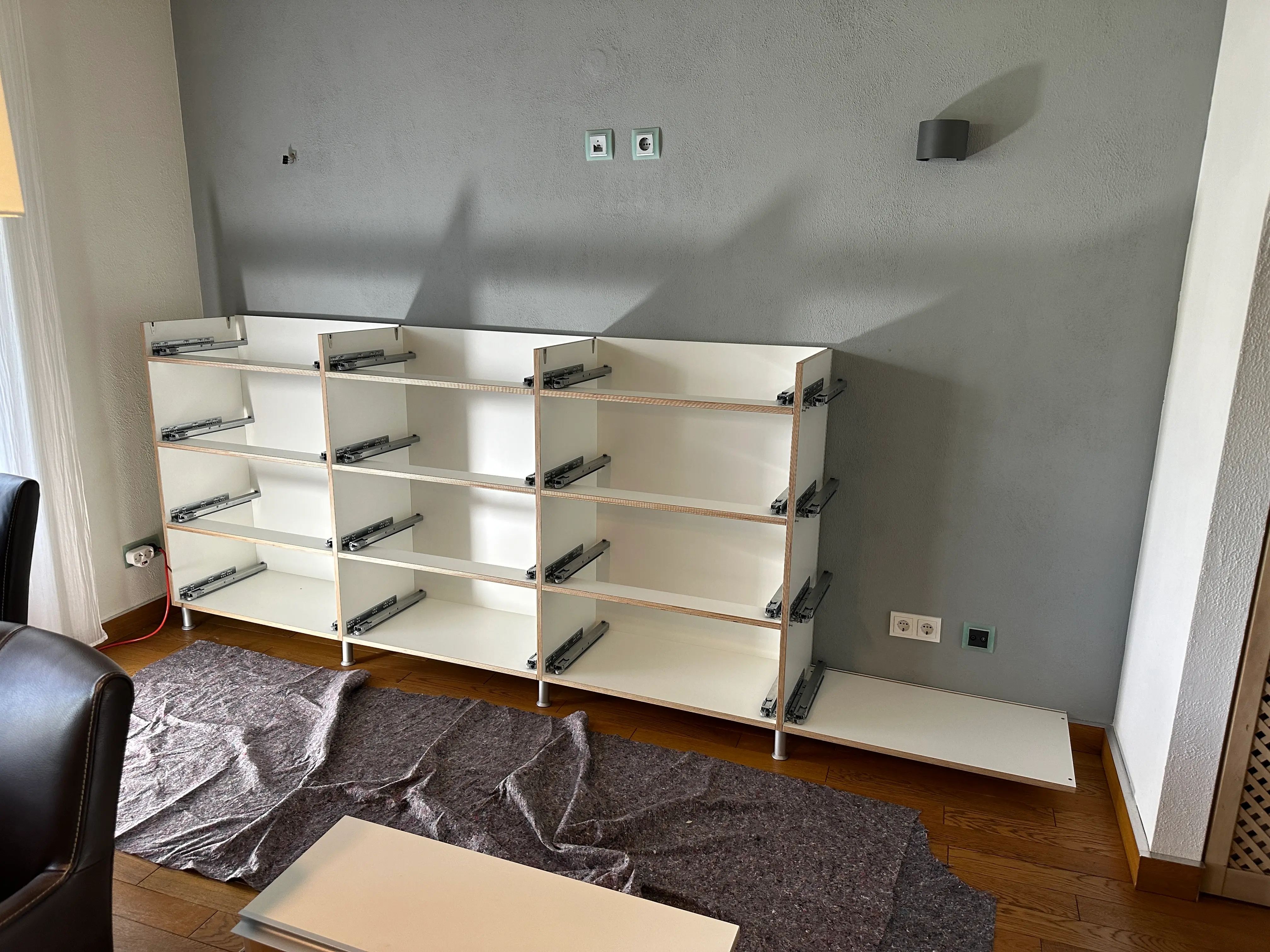 Montage des maßgefertigten Multiplex-Sideboards während des Aufbaus im Wohnzimmer in Viernheim