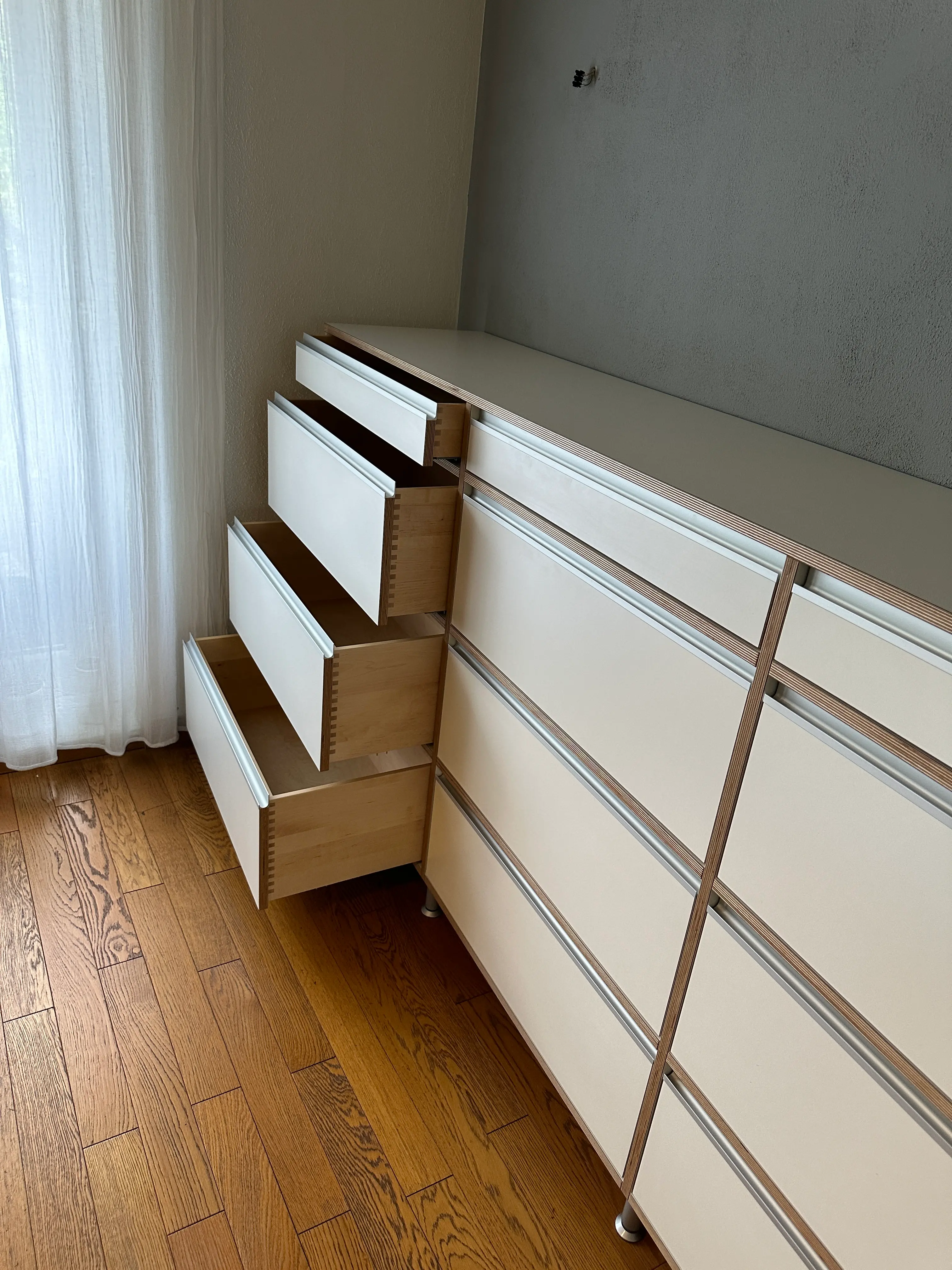 Geöffnete fingergezinkte Schubkästen aus Birke an einem maßgefertigten Multiplex-Sideboard mit weißen HPL-Fronten in Viernheim