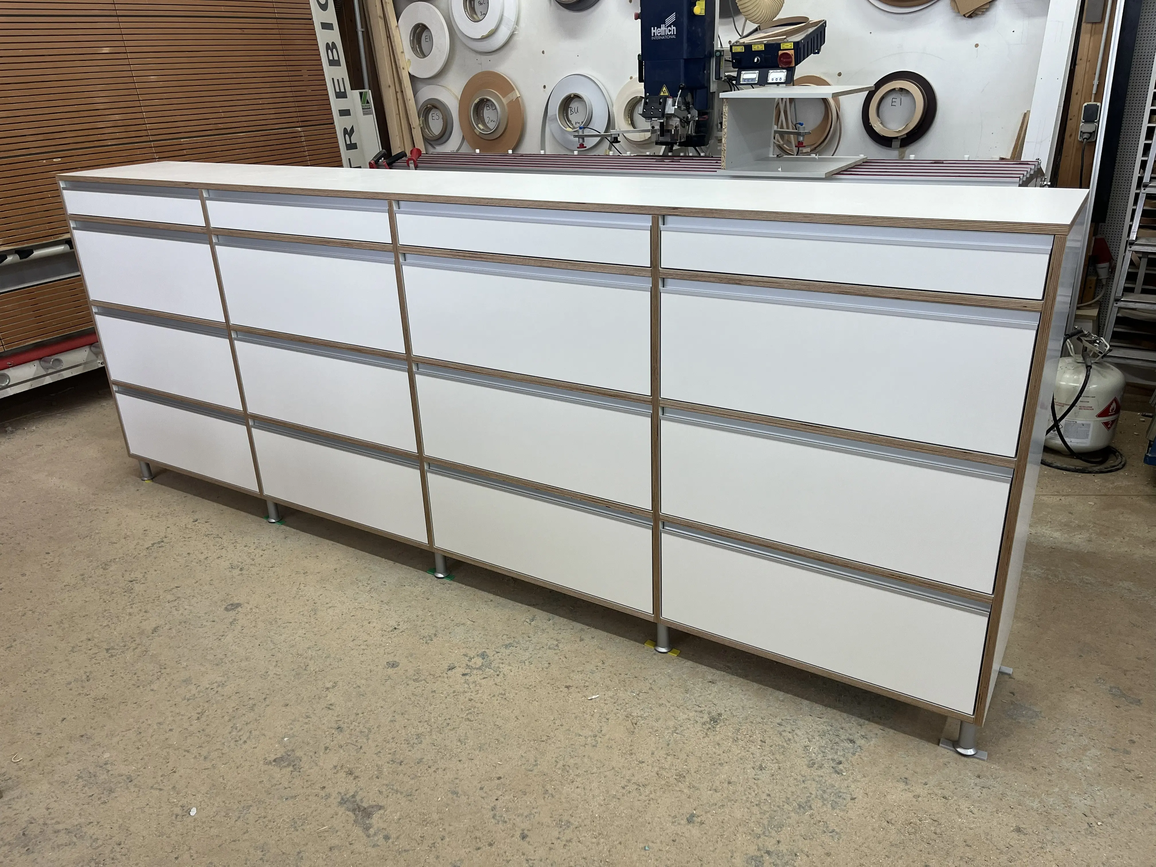 Maßgefertigtes Multiplex-Sideboard mit weißen HPL-Fronten und geölten Sichtkanten während der Fertigung in der Schreinerei