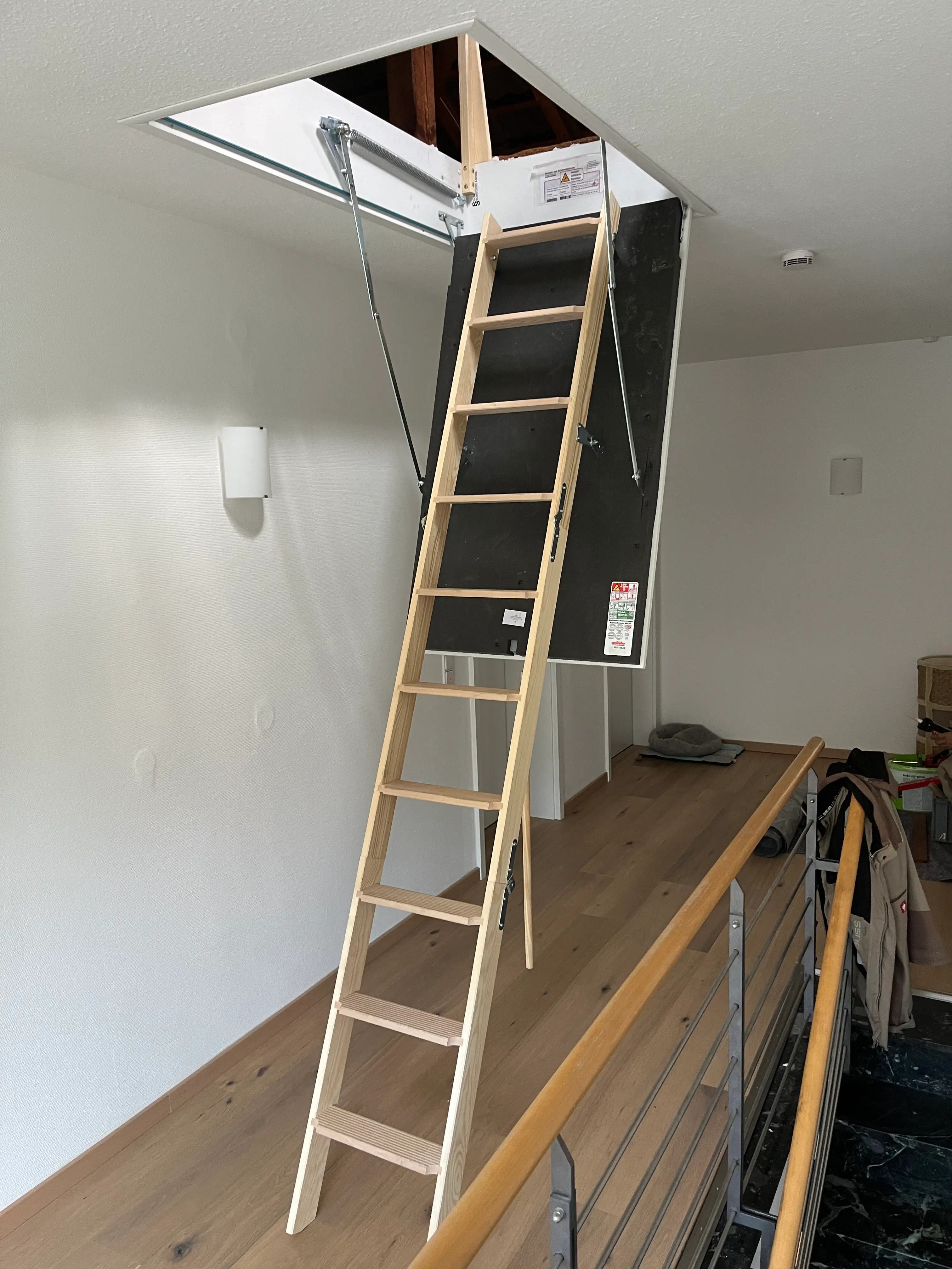 Ausgeklappte Wellhöfer Dachlukentreppe mit wärmegedämmtem Deckenelement und Holzleiter in Weinheim.