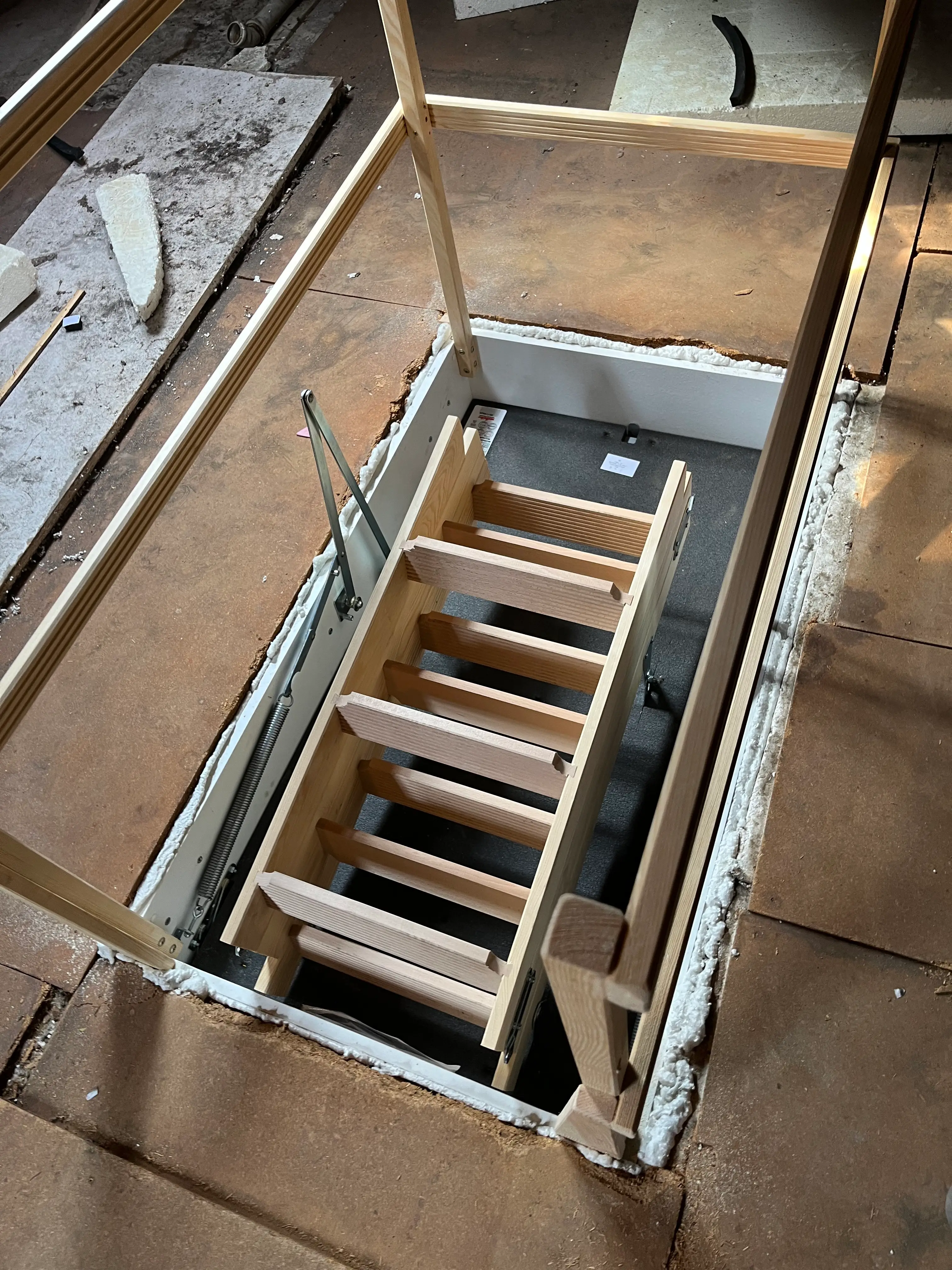 Schutzgeländer und Holzleiter einer Wellhöfer Dachlukentreppe im Dachbodenbereich in Weinheim.