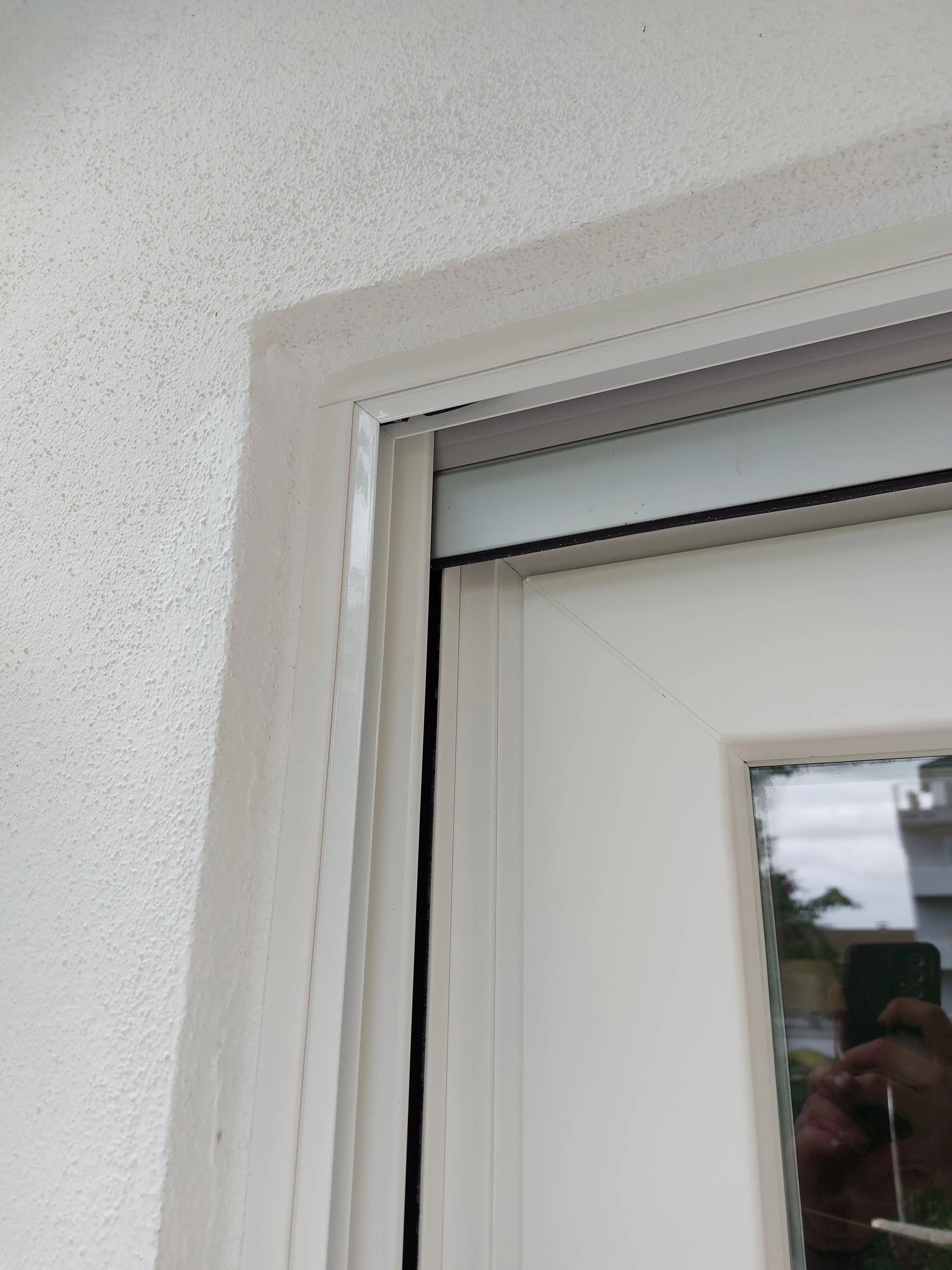 Detailansicht des schlanken Aluminiumrahmens einer weißen Neher Insektenschutzanlage mit präziser Eckausbildung.