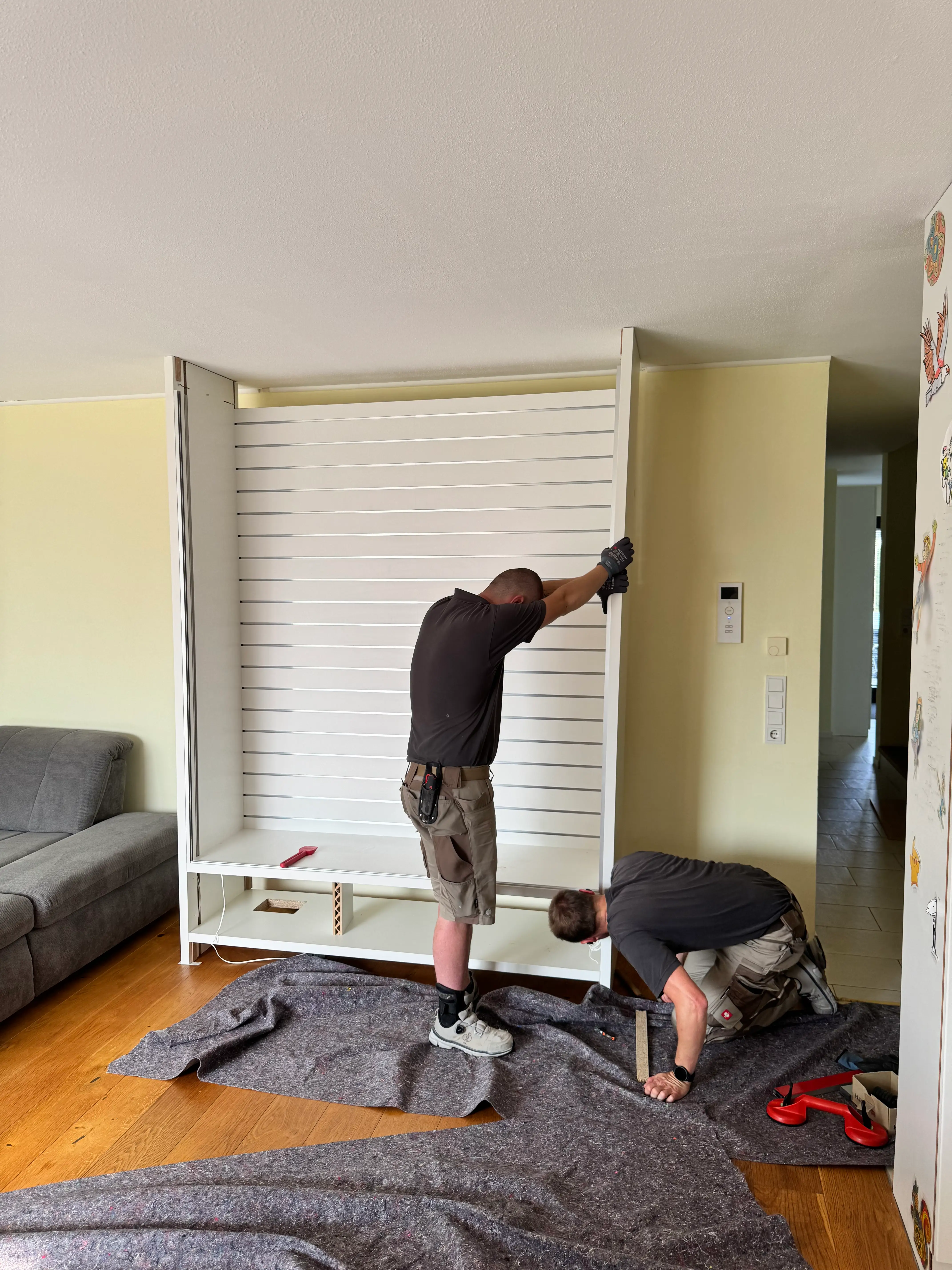 Montage eines maßgefertigten Präsentationsmöbels mit beleuchteter Rückwand und verstellbarem Regalsystem in Lampertheim.