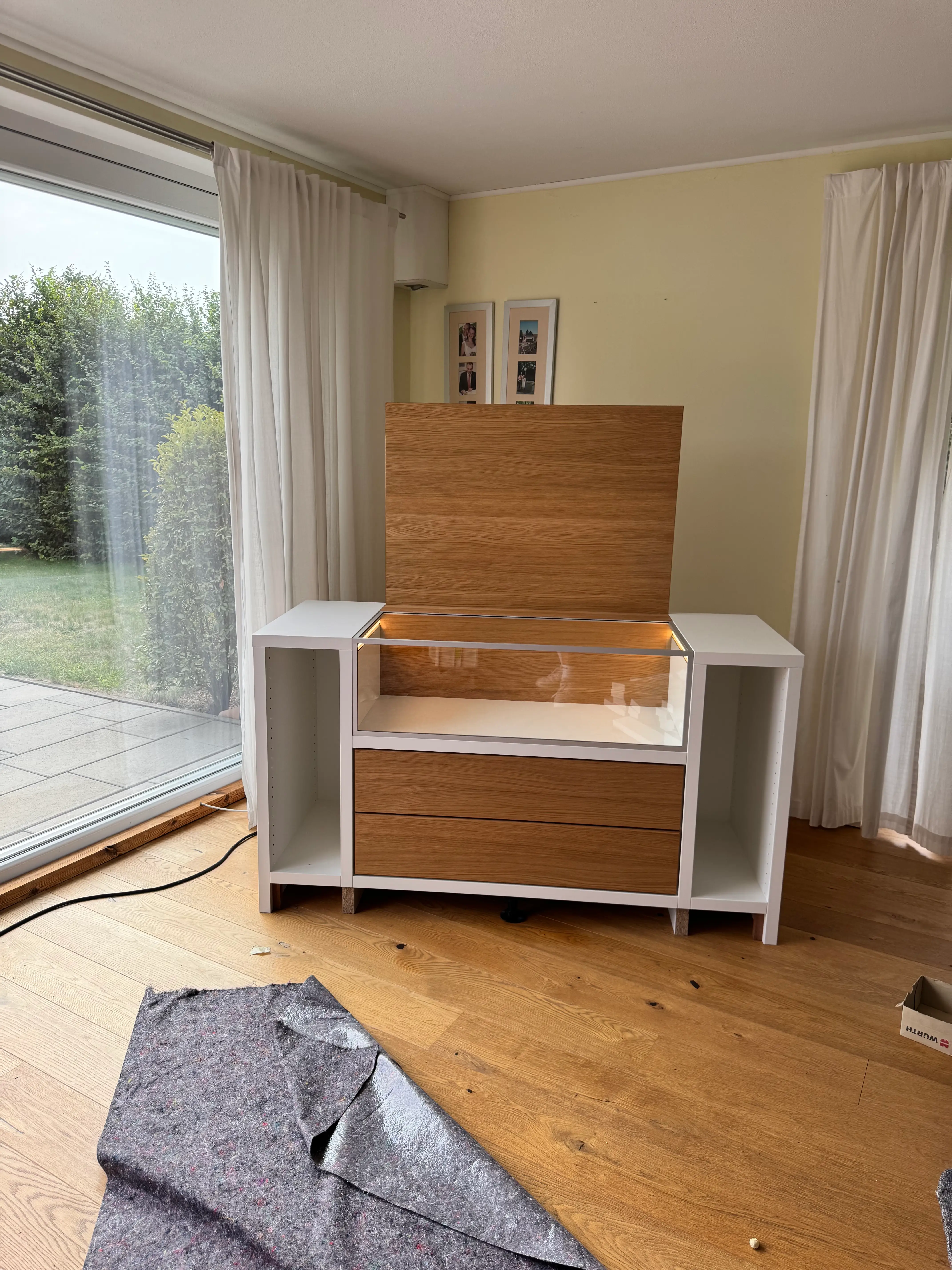 Individuelles TV-Möbel mit integrierter Glasvitrine, Beleuchtung und Fronten in geölter Eiche zur Präsentation von Modellbau-Fahrzeugen in Lampertheim.