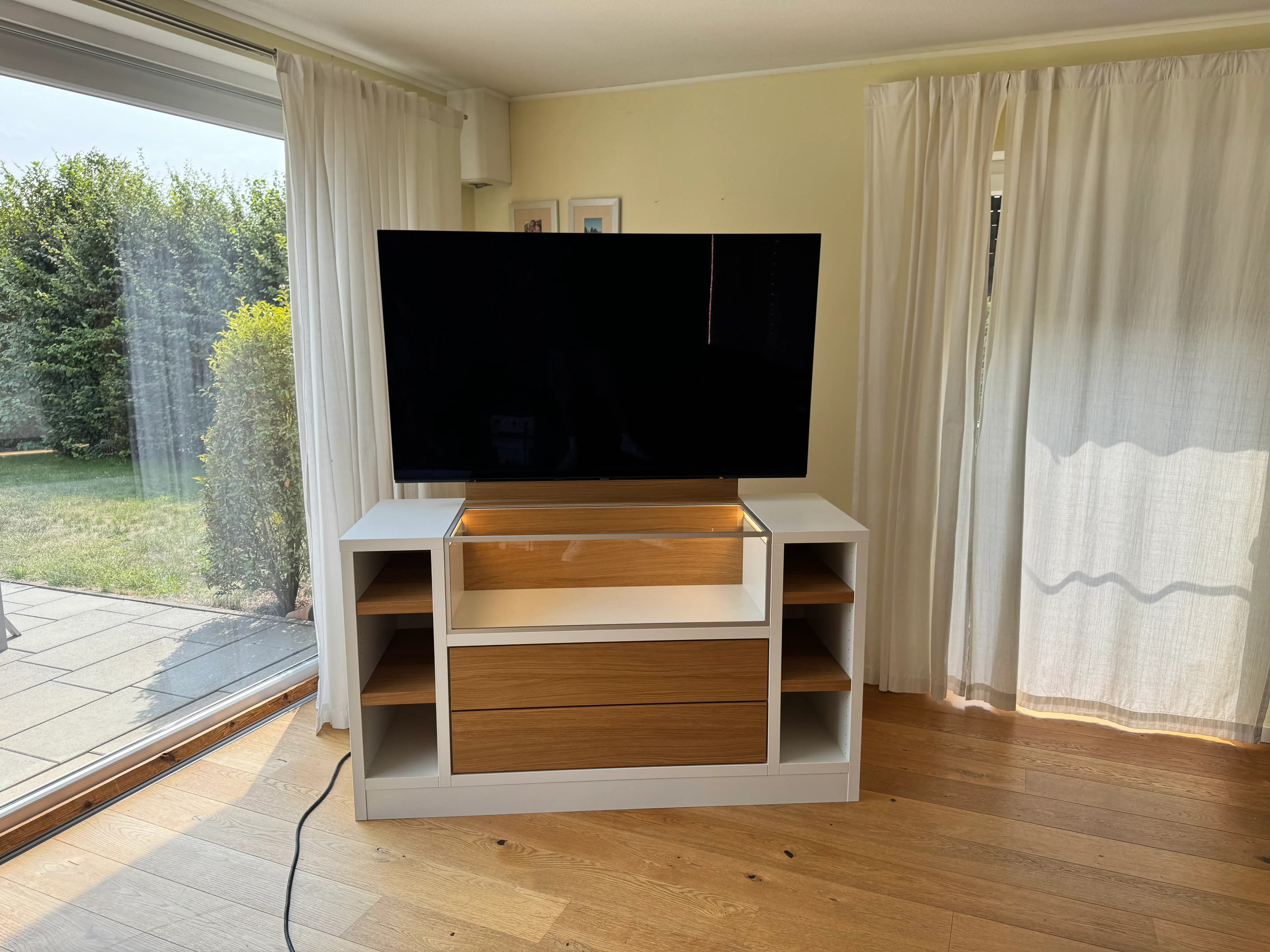 Individuelles TV-Möbel mit integrierter Glasvitrine, beleuchtetem Präsentationsfach und Fronten in geölter Eiche in Lampertheim.