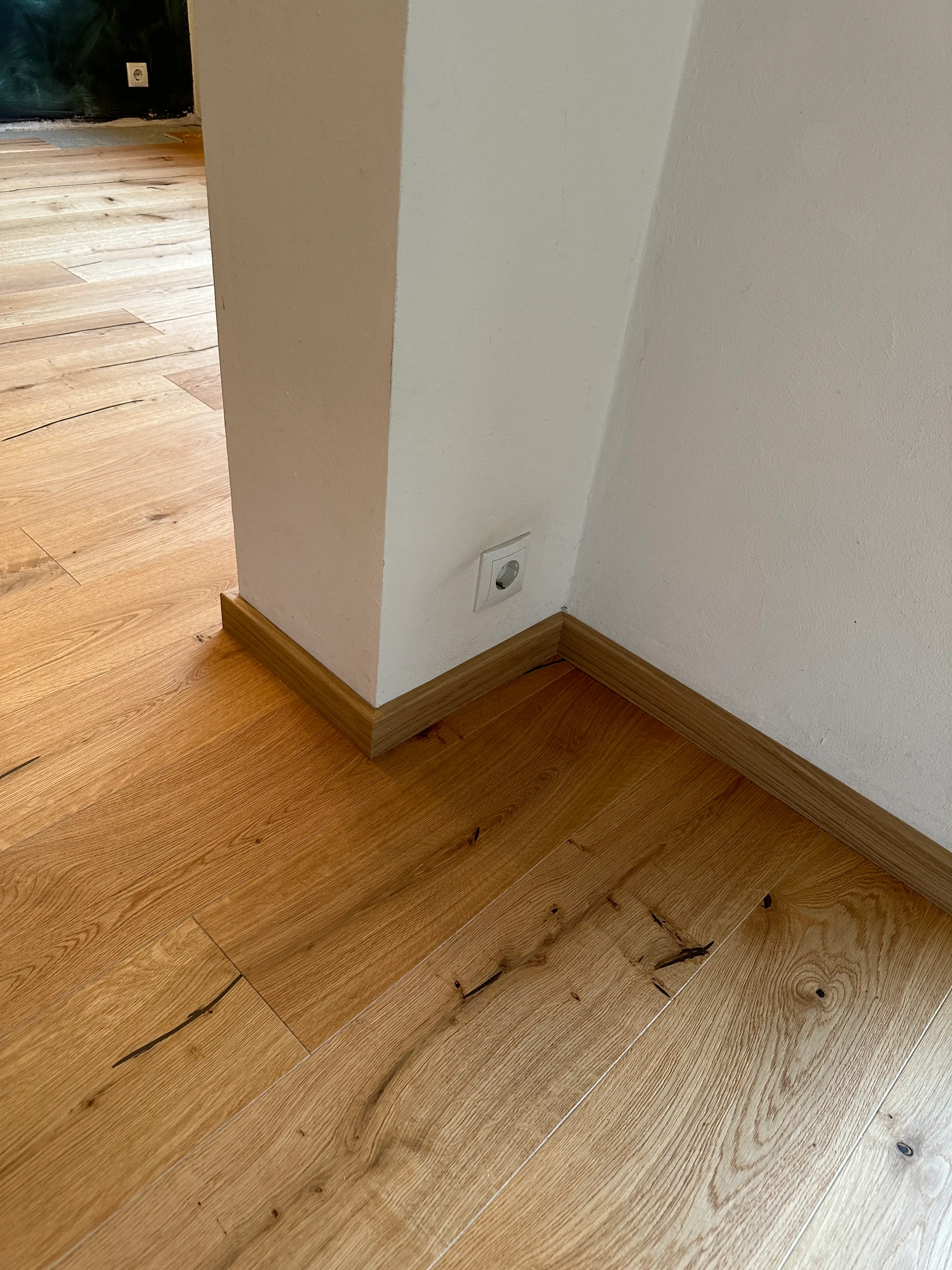 Detailansicht der geölten Eichensockelleiste passend zum HARO Eichenparkett mit sauber ausgeführter Innenecke in Viernheim.
