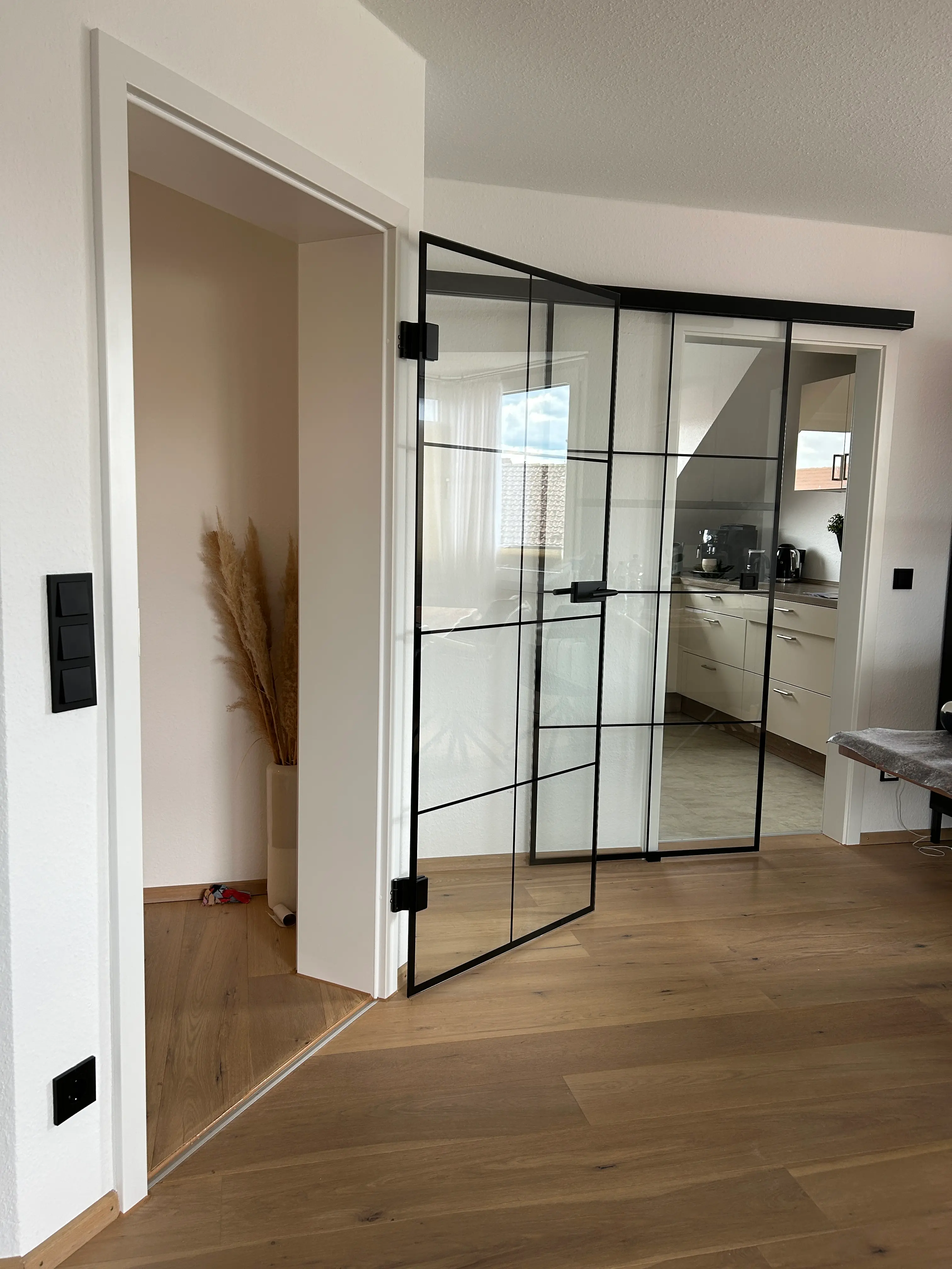 Transparente Loft-Glastür mit schwarzem Sprossendesign im offenen Wohnbereich in Heddesheim