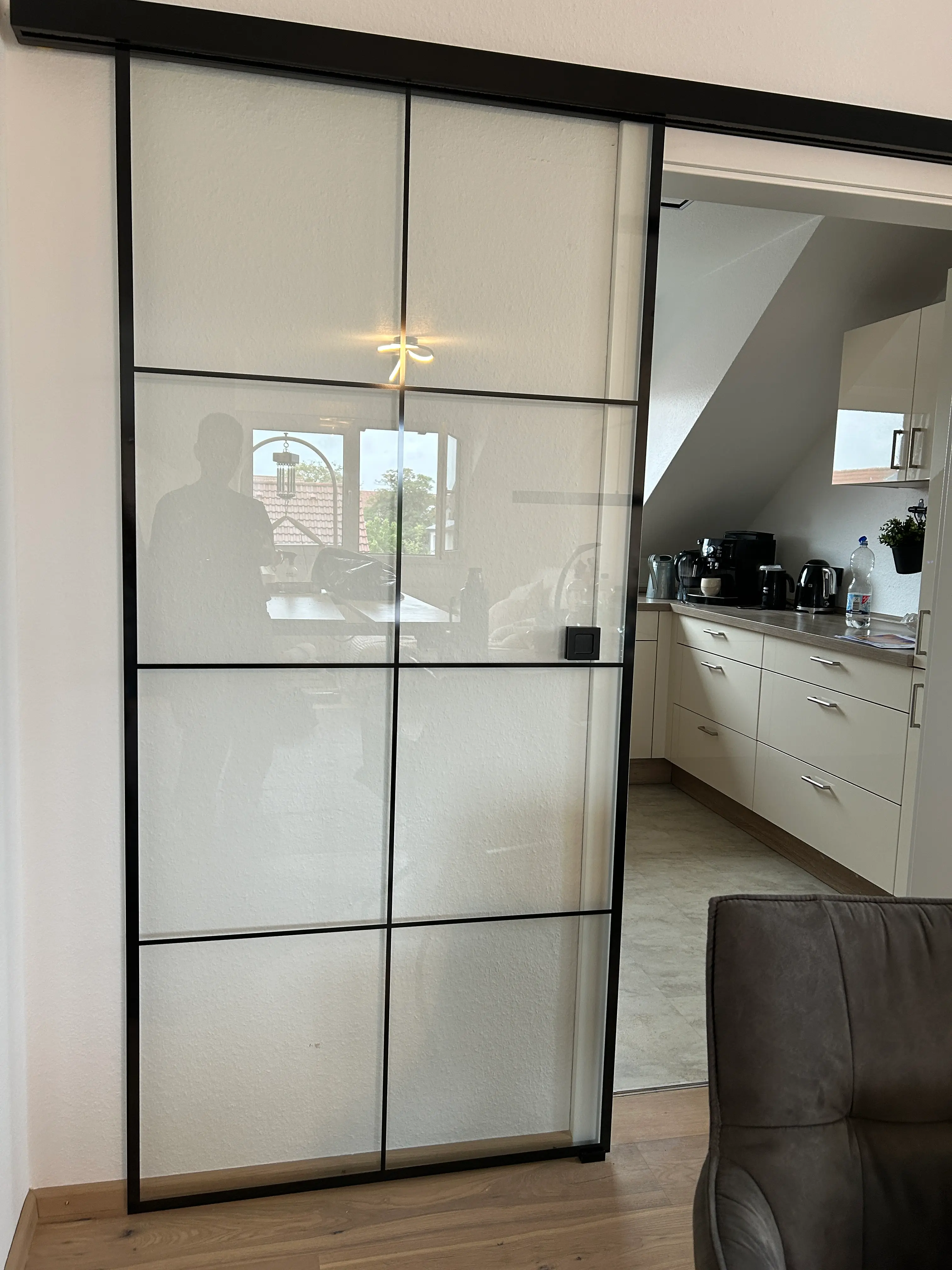 Transparente Loft-Glasschiebetür mit schwarzem Sprossendesign im Küchenbereich in Heddesheim