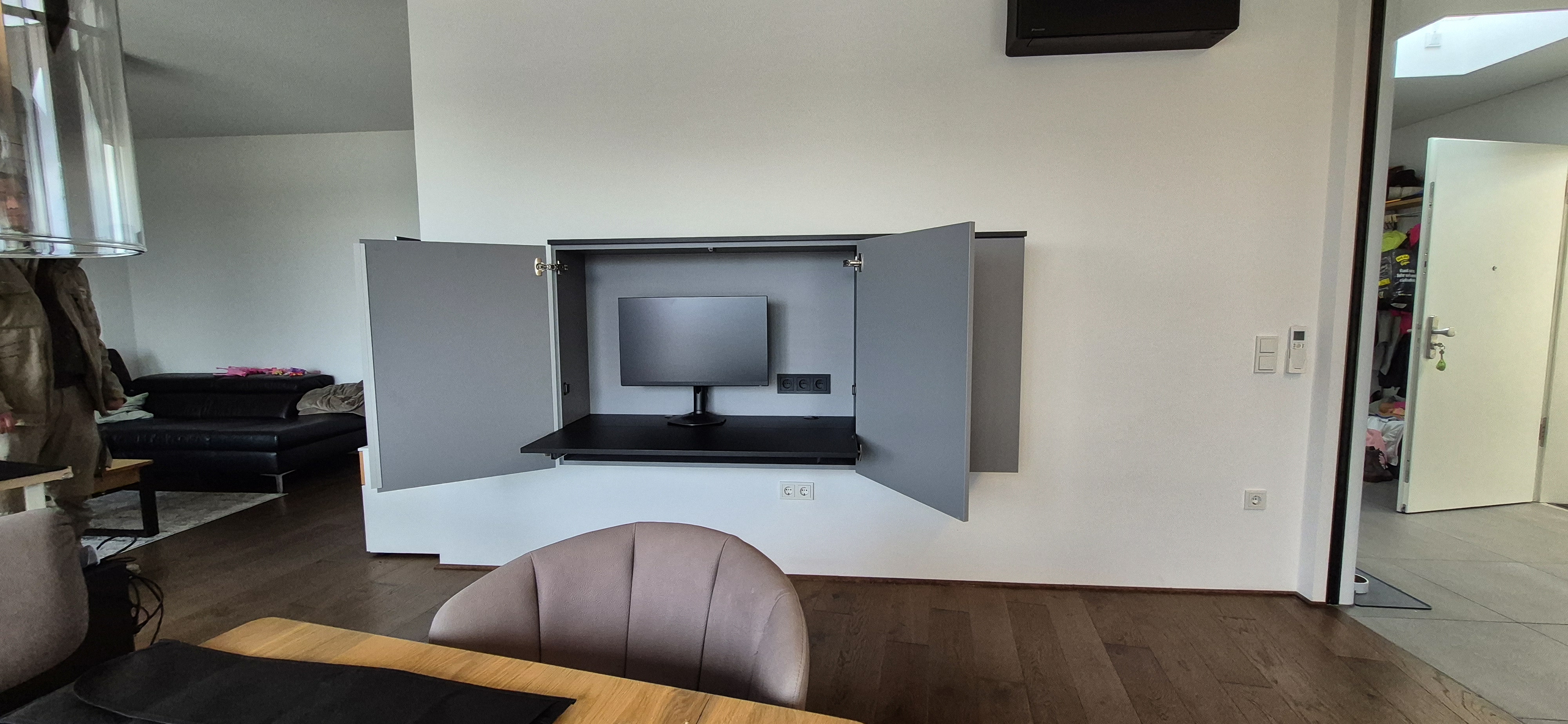 Geöffneter Homeoffice-Schrank nach Maß mit integrierter Arbeitsfläche, Monitorplatz und verstecktem Arbeitsplatz in Plankstadt.
