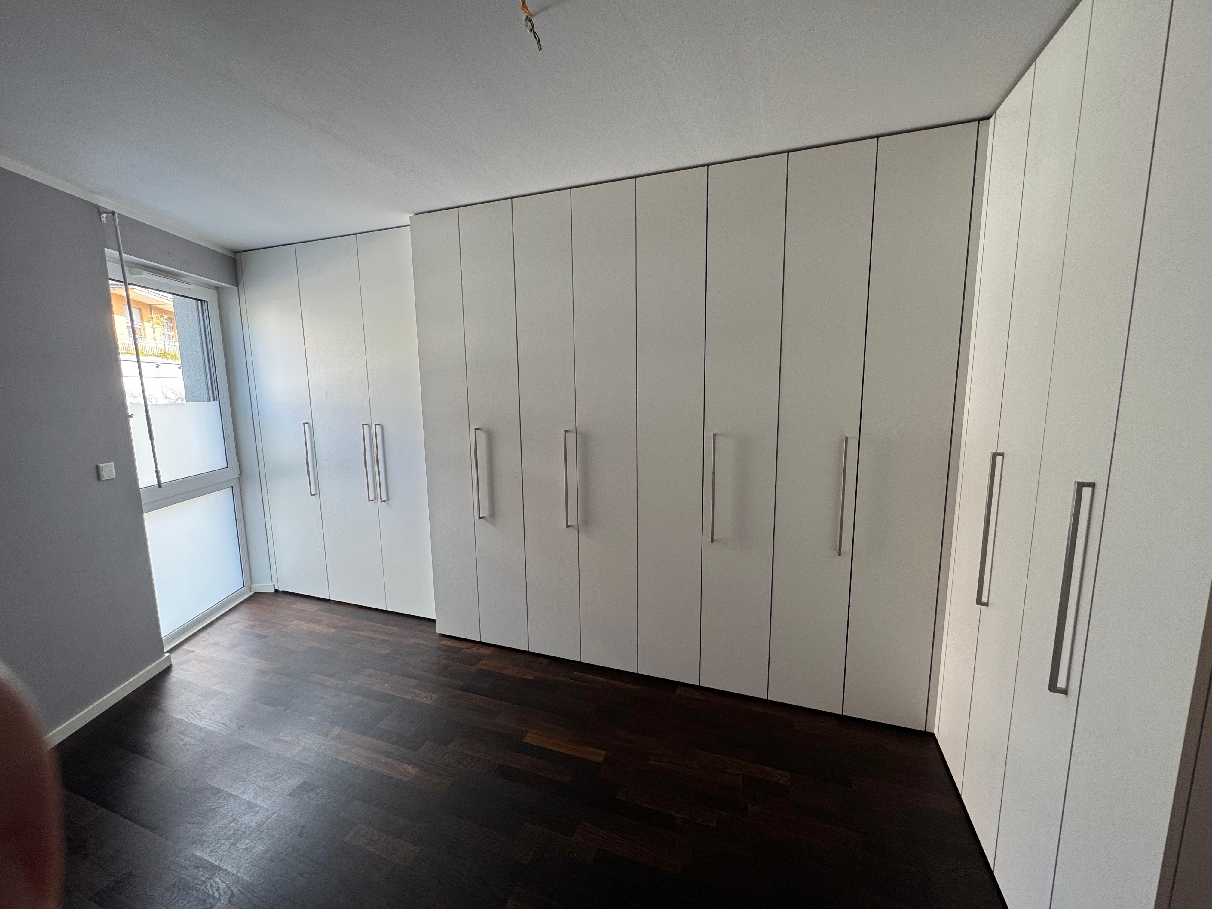 Maßgefertigter deckenhoher Eck-Einbauschrank mit integrierter Homeoffice-Lösung und großzügigem Stauraum in einem Schlafzimmer in Weinheim.