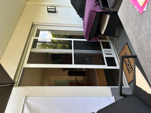 Geöffnete Neher Insektenschutz-Schiebetür mit Katzenklappe an einer Terrassentür in Ilvesheim.