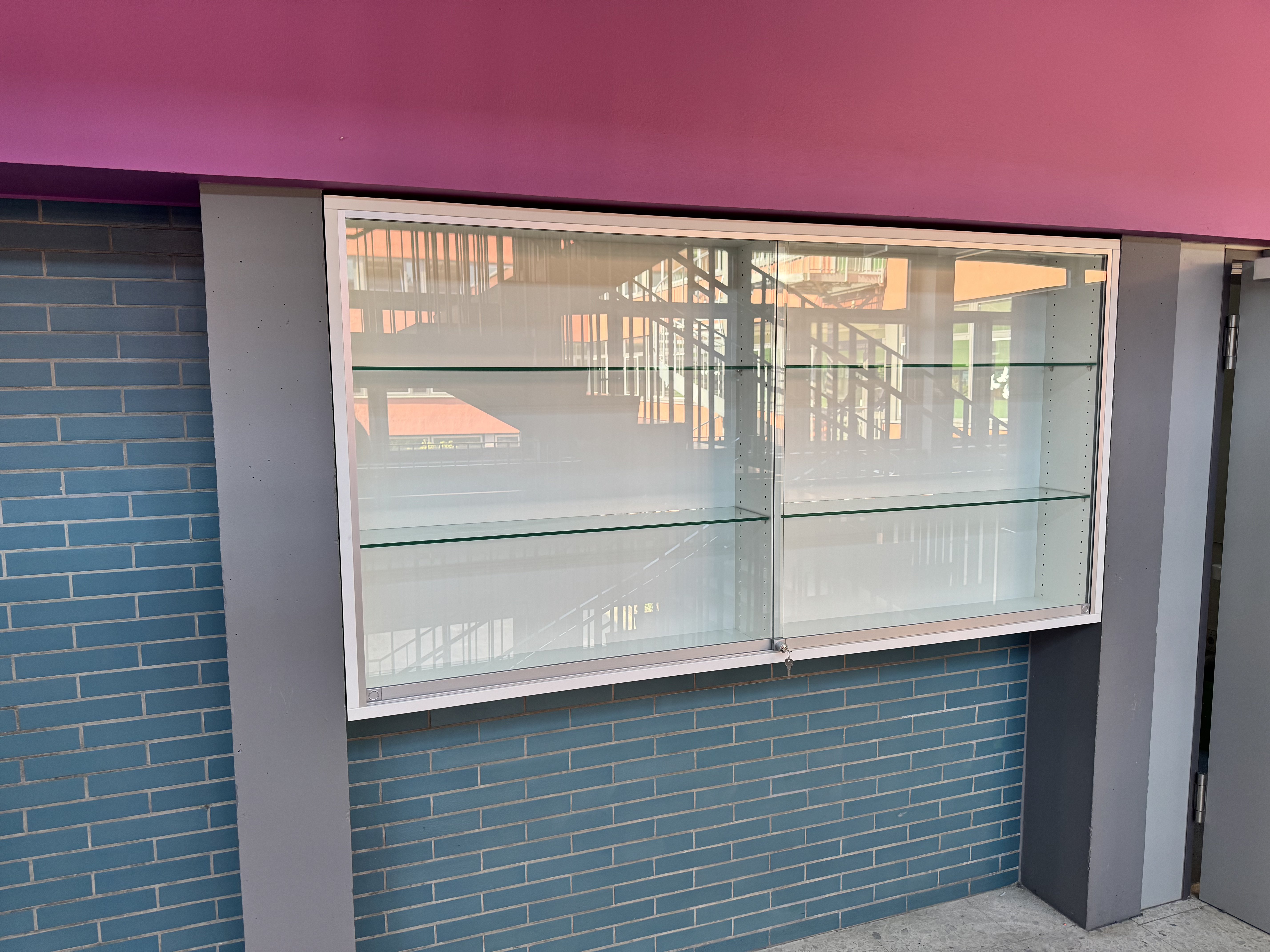 Maßgefertigte Einbauvitrine mit Glasschiebetüren in einer Wandnische in Viernheim