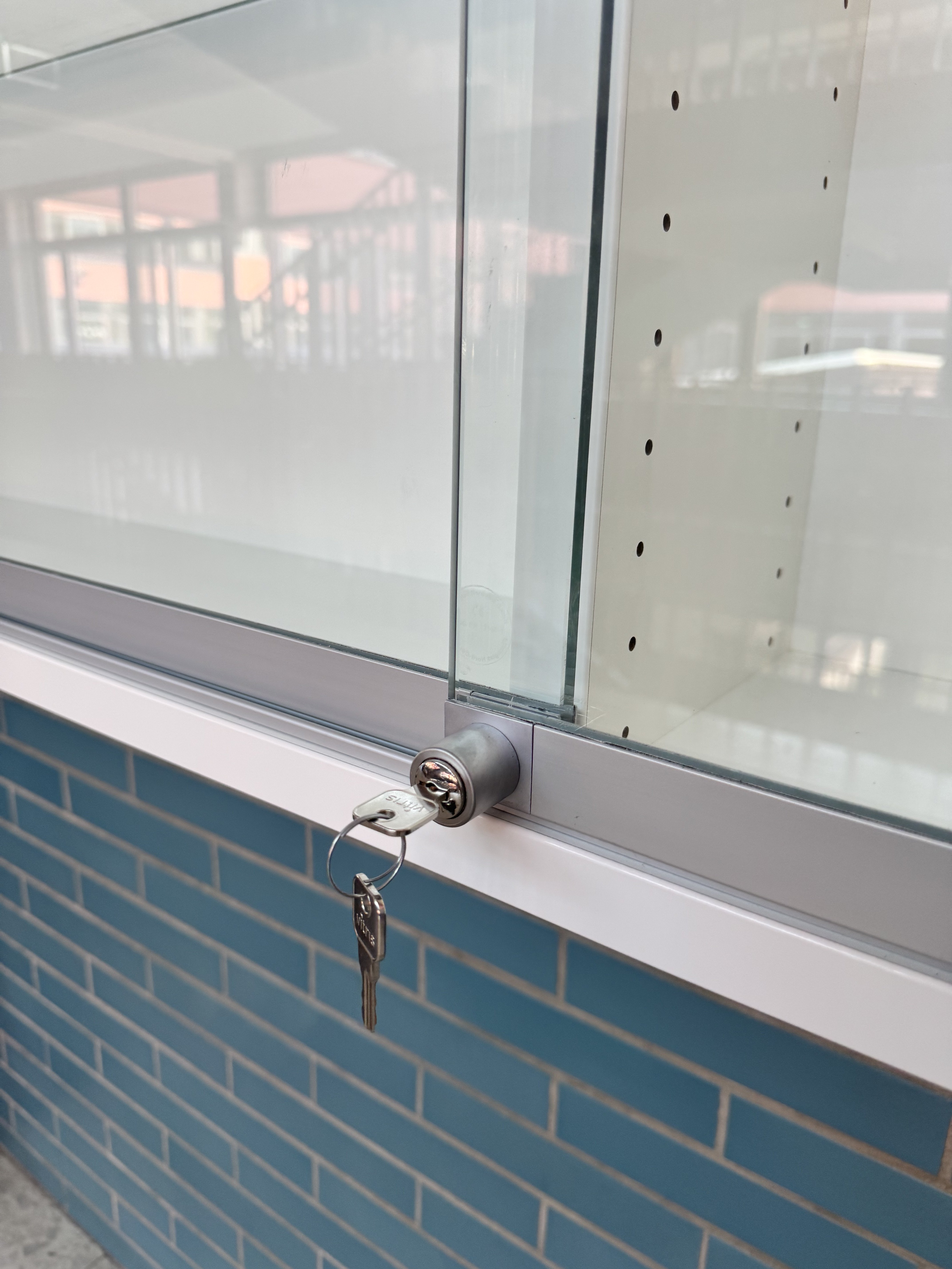 Detailaufnahme des abschließbaren Zylinderschlosses einer maßgefertigten Glasvitrine