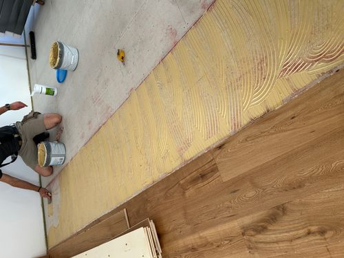 Vollflächige Verklebung eines Eichenparketts auf vorbereitetem Estrich während der Parkettverlegung in Viernheim.
