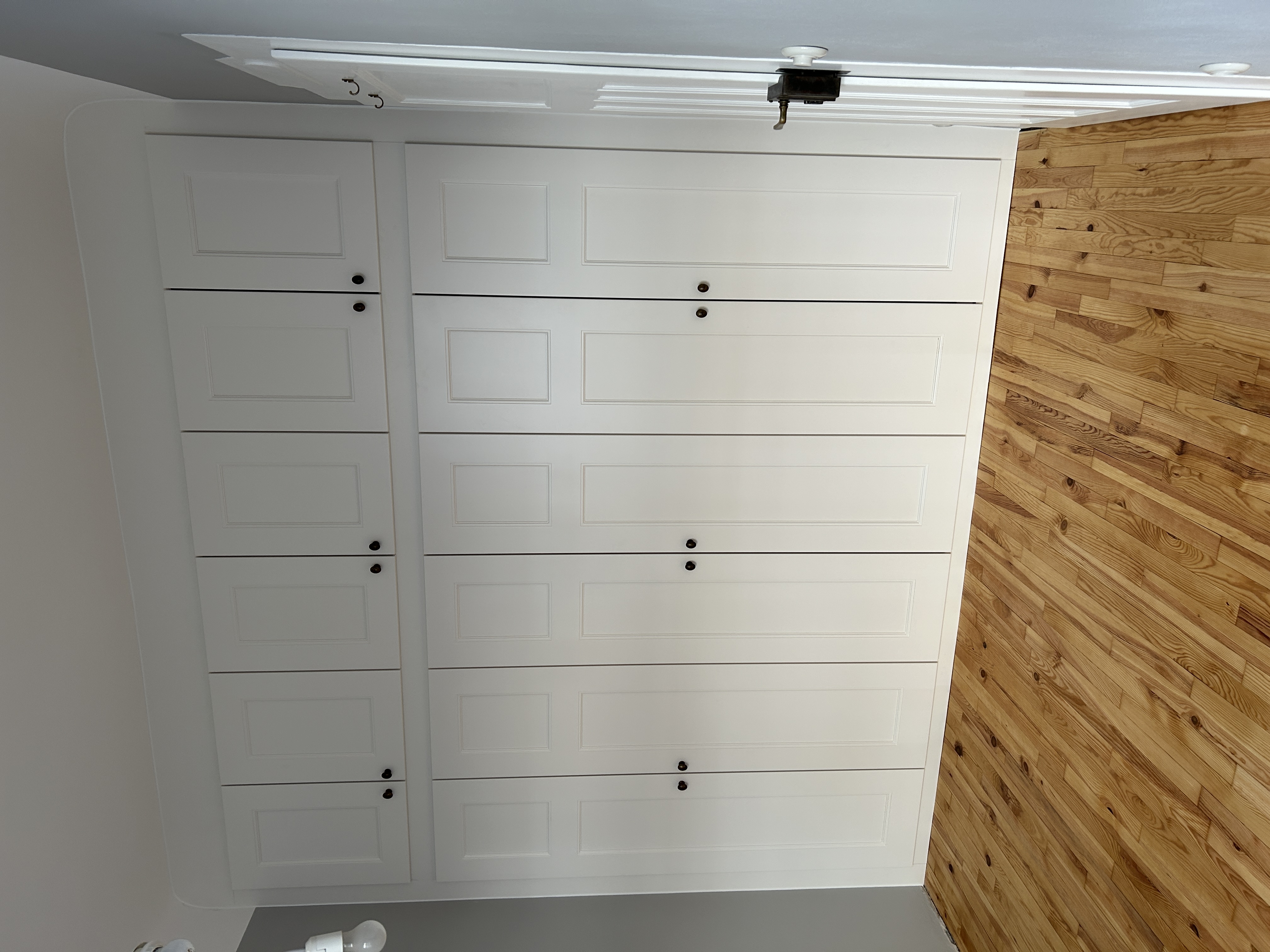 Maßgefertigter weißer Einbauschrank in Mannheim mit zwölf Rahmentüren, deckenhoher Ausführung und passgenauer Anpassung an den Raum.
