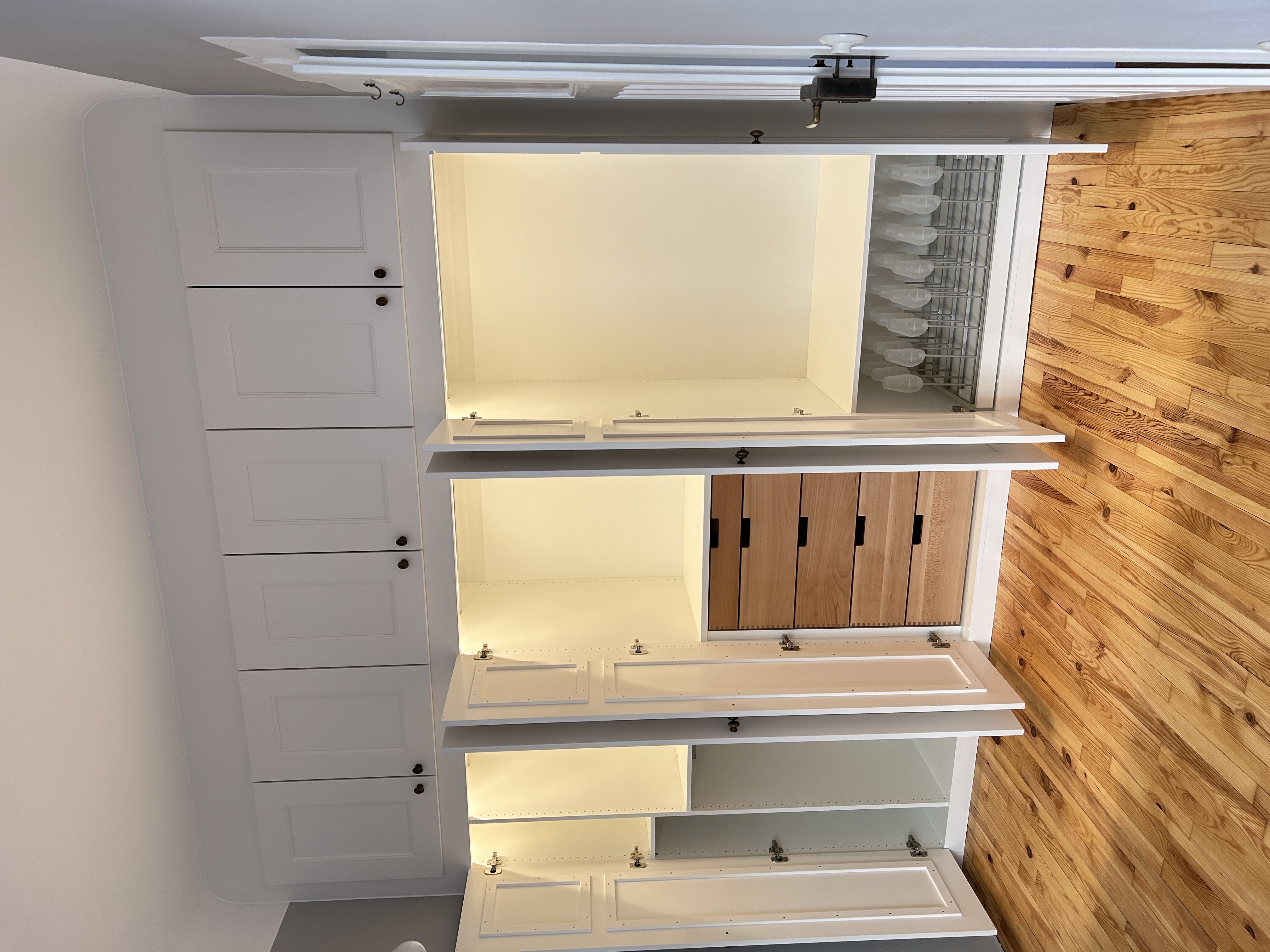 Geöffneter maßgefertigter Einbauschrank in Mannheim mit integrierter LED-Beleuchtung, Schubkästen aus Buche und ausziehbarem Schuhständer.