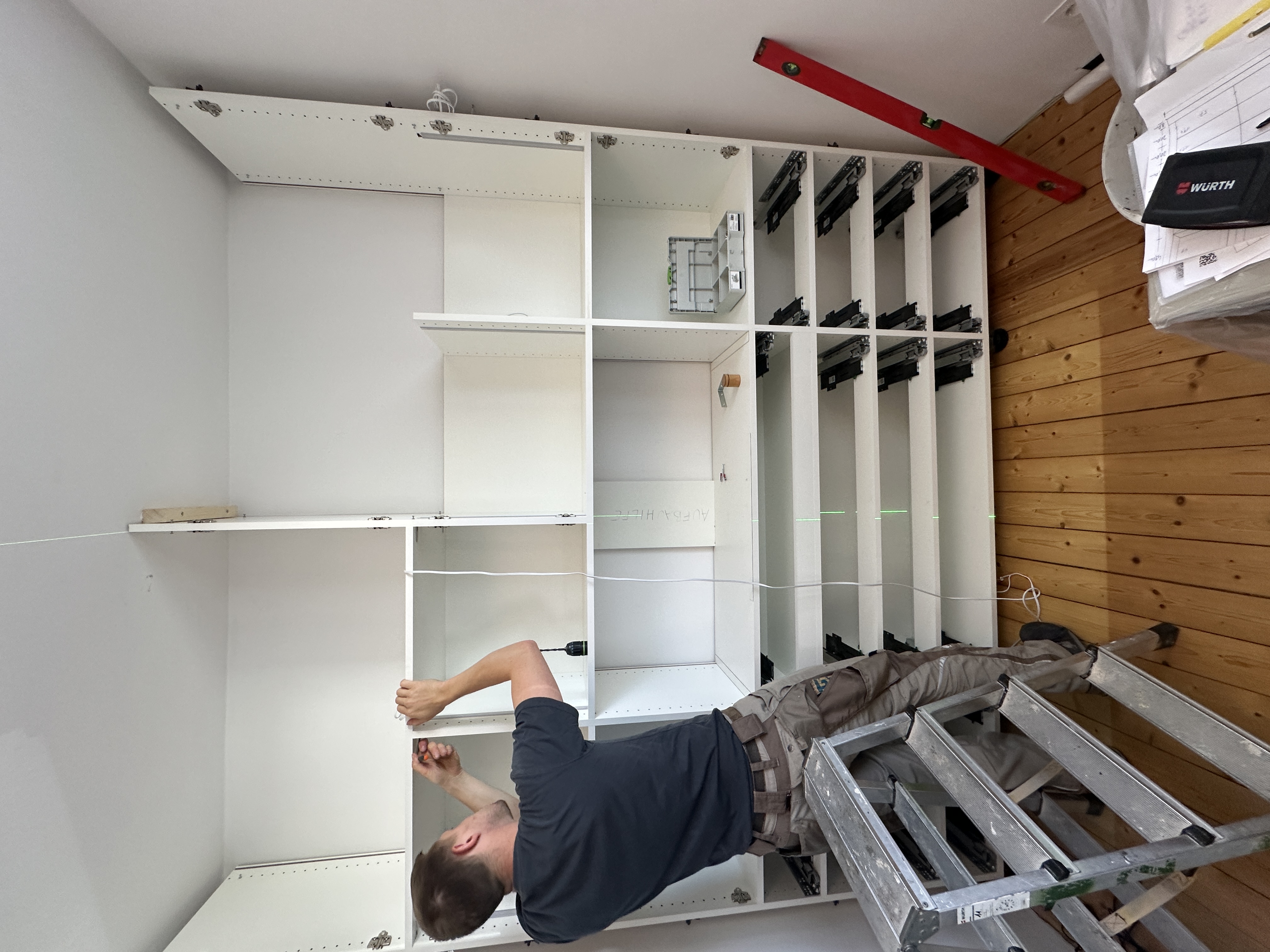 Aufbau des maßgefertigten Einbauschranks mit Schubkastenauszügen während der Montage