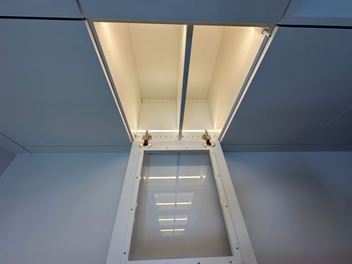 Detail der maßgefertigten Büromöbel mit verglaster Vitrine und integrierter warmweißer LED-Beleuchtung