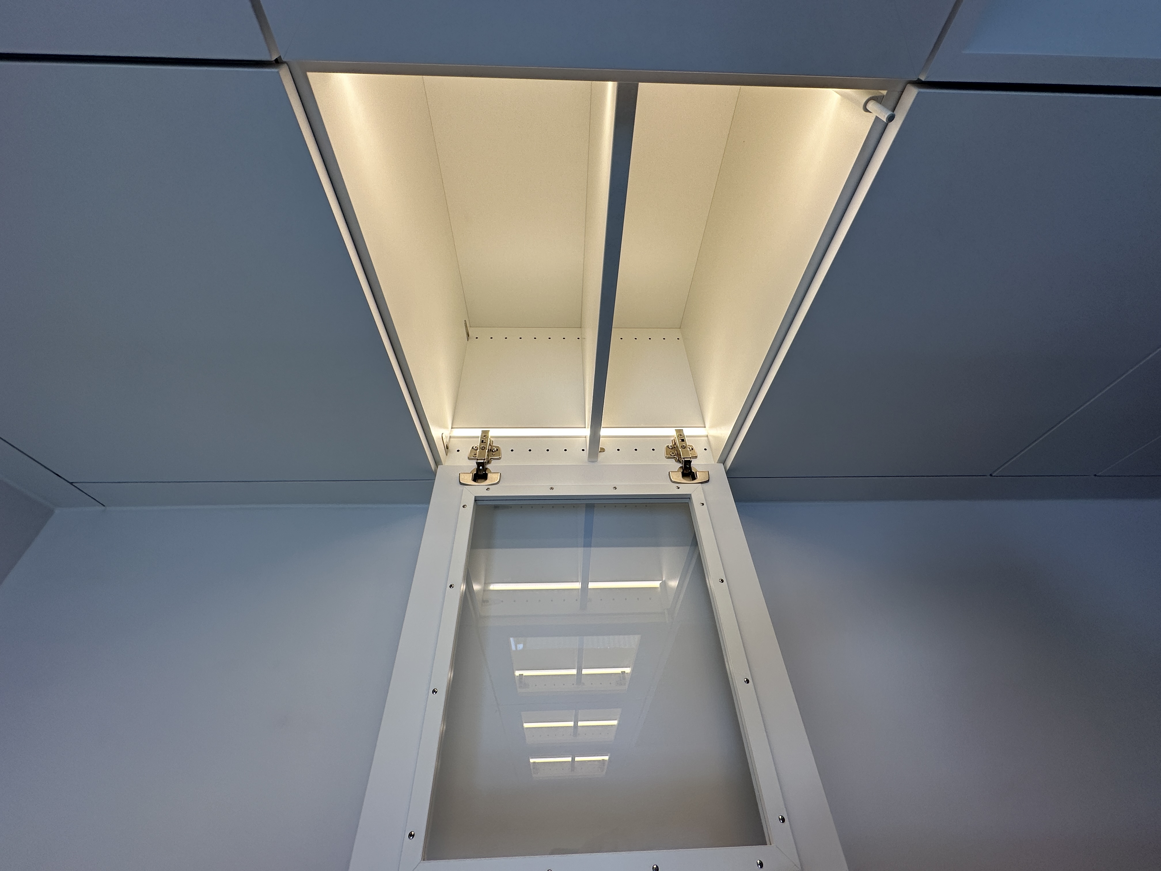 Detail der maßgefertigten Büromöbel mit verglaster Vitrine und integrierter warmweißer LED-Beleuchtung