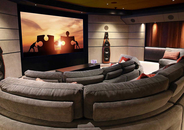 Curved home theatre seating with wall lighting creating a cinematic ambience.