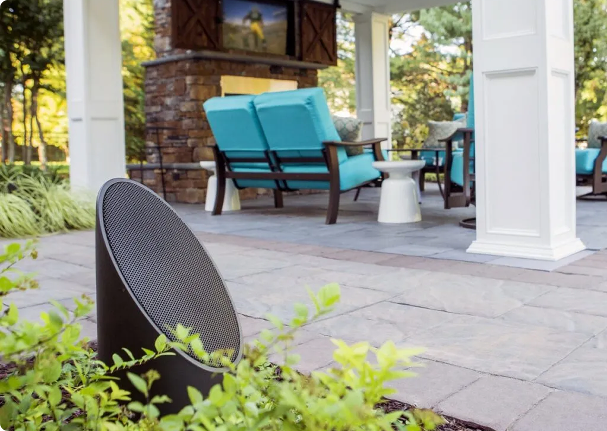 Outdoor patio area with weather-resistant speakers providing multi-room sound.
