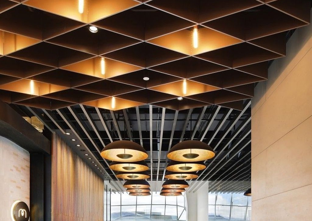 Contemporary architectural ceiling featuring recessed grid lighting that highlights texture and depth in the space.