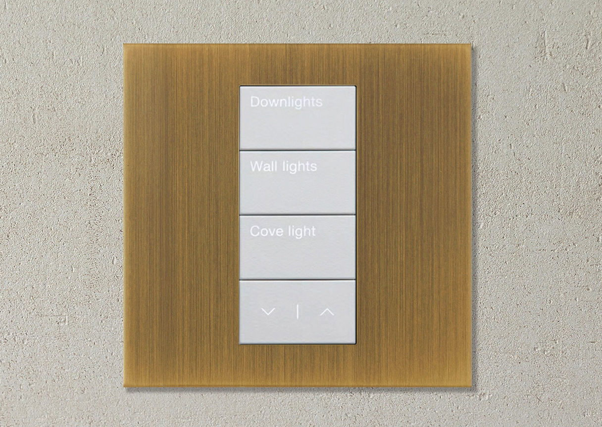 Brass wall-mounted smart lighting keypad with programmable scene controls for outdoor and architectural lighting.