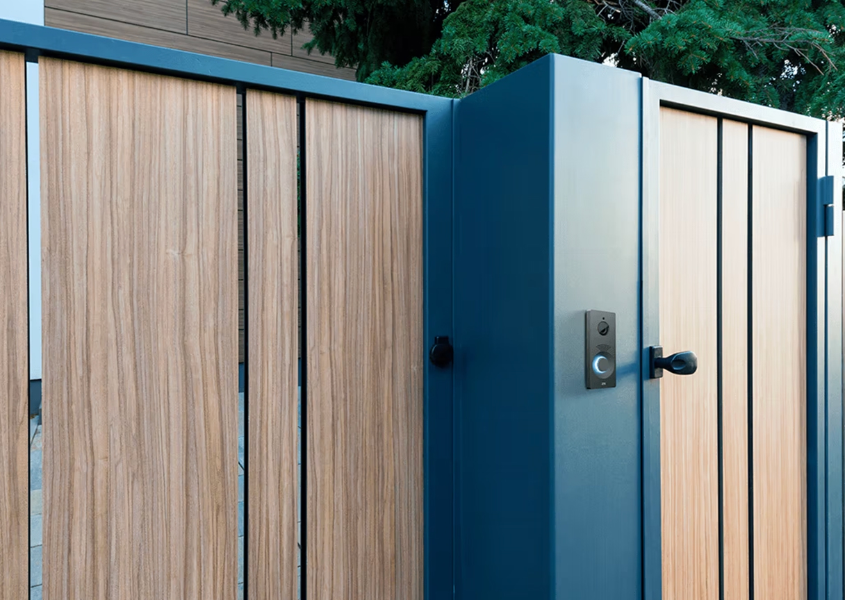 Keypad and intercom mounted beside timber entry gate, offering contactless access control.