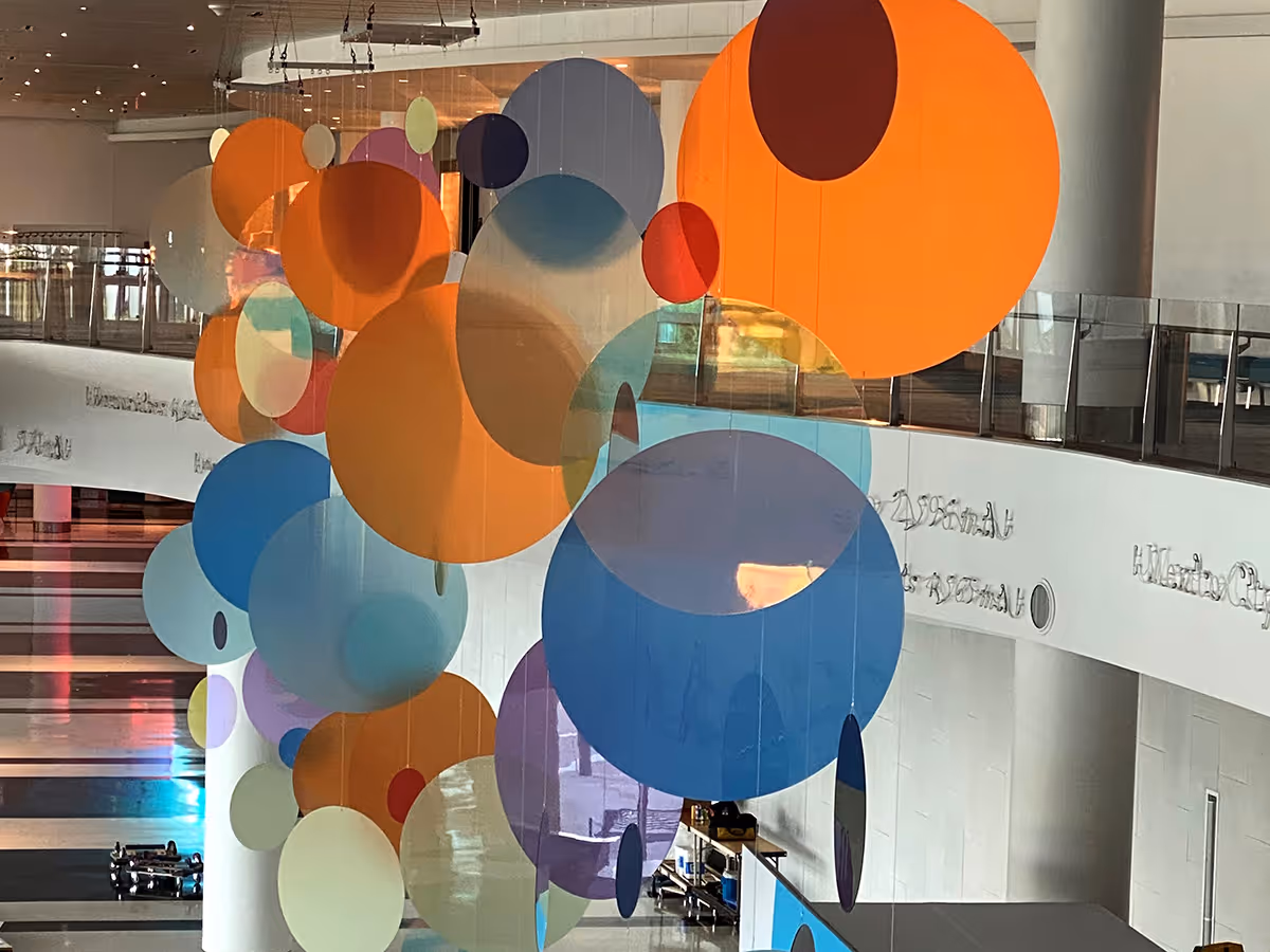 Reception desk with Cisco logo, woman working on a laptop, and large wall mural of elephants behind glass panels.