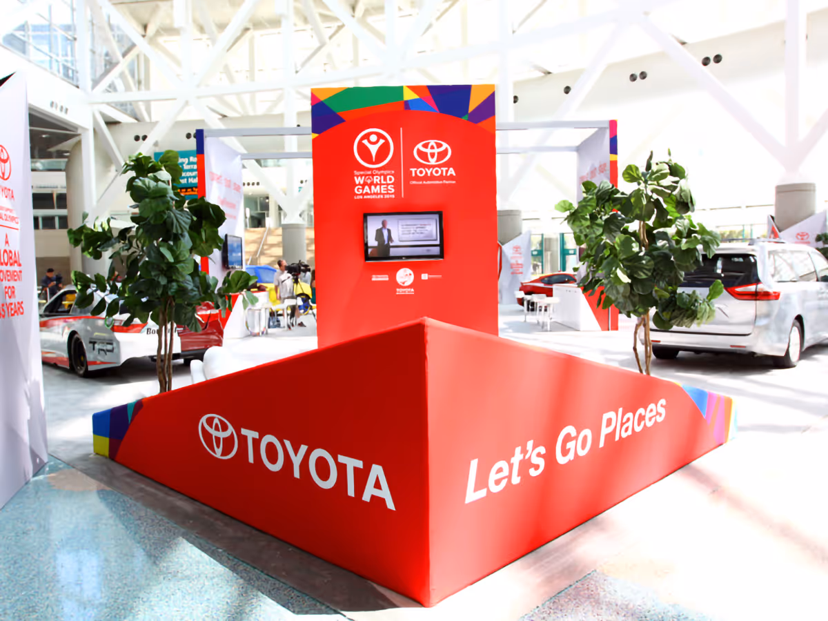 Red Toyota promotional booth at an indoor event with 'Let's Go Places' slogan and Special Olympics World Games logos.