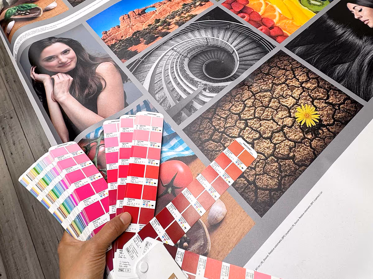 Black multi-compartment display shaped like an X holding orange padded material, leather pieces, patterned fabric, and an orange boot with printed text.