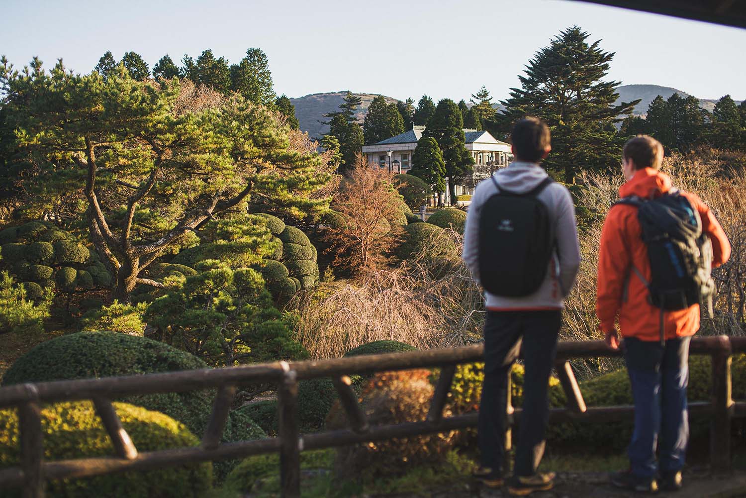Visitors looking out over the manicured gardens of Onshi Hakone Park toward the Lakeside Observation Building