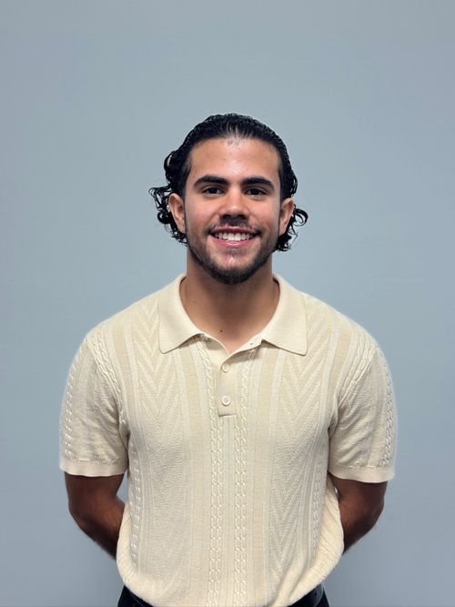 Portrait of Fernando Vera smiling, wearing a cream knit polo shirt, used in the About section to introduce the founder and build trust