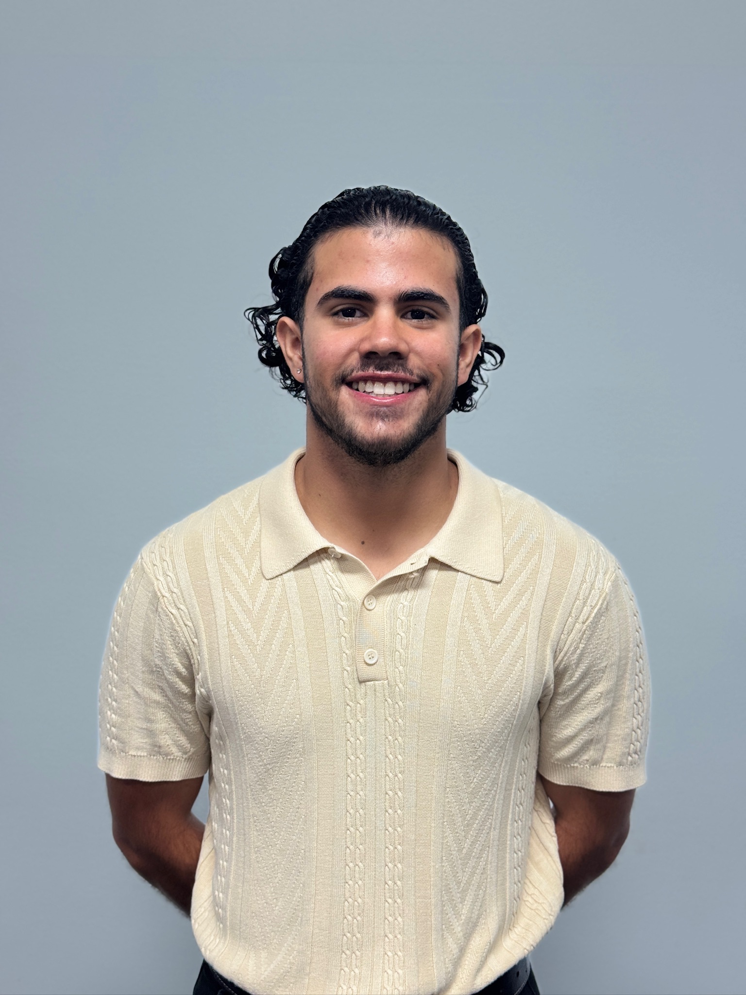 Portrait of Fernando Vera smiling, wearing a cream knit polo shirt, used in the About section to introduce the founder and build trust