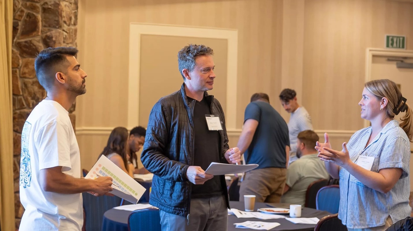 A person holding a paper in front of a group of peopleDescription automatically generated