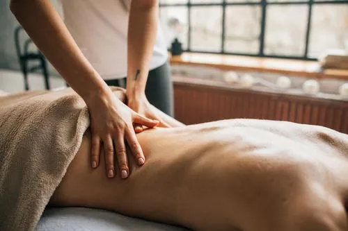 Hands massaging a client’s lower back