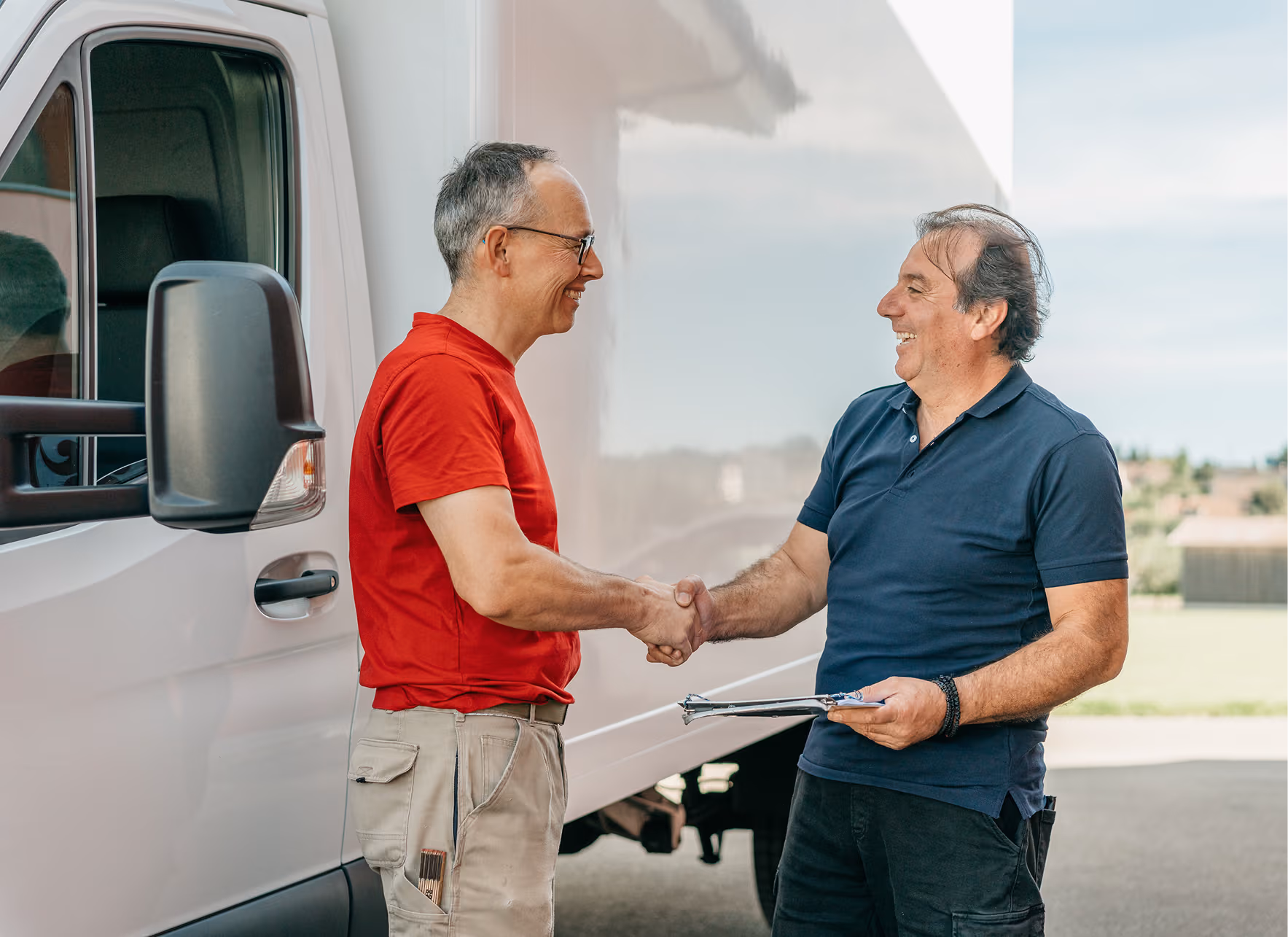 Roland Koch Transporte Schweiz: Zwei Mitarbeiter schütteln Hände am Lieferwagen