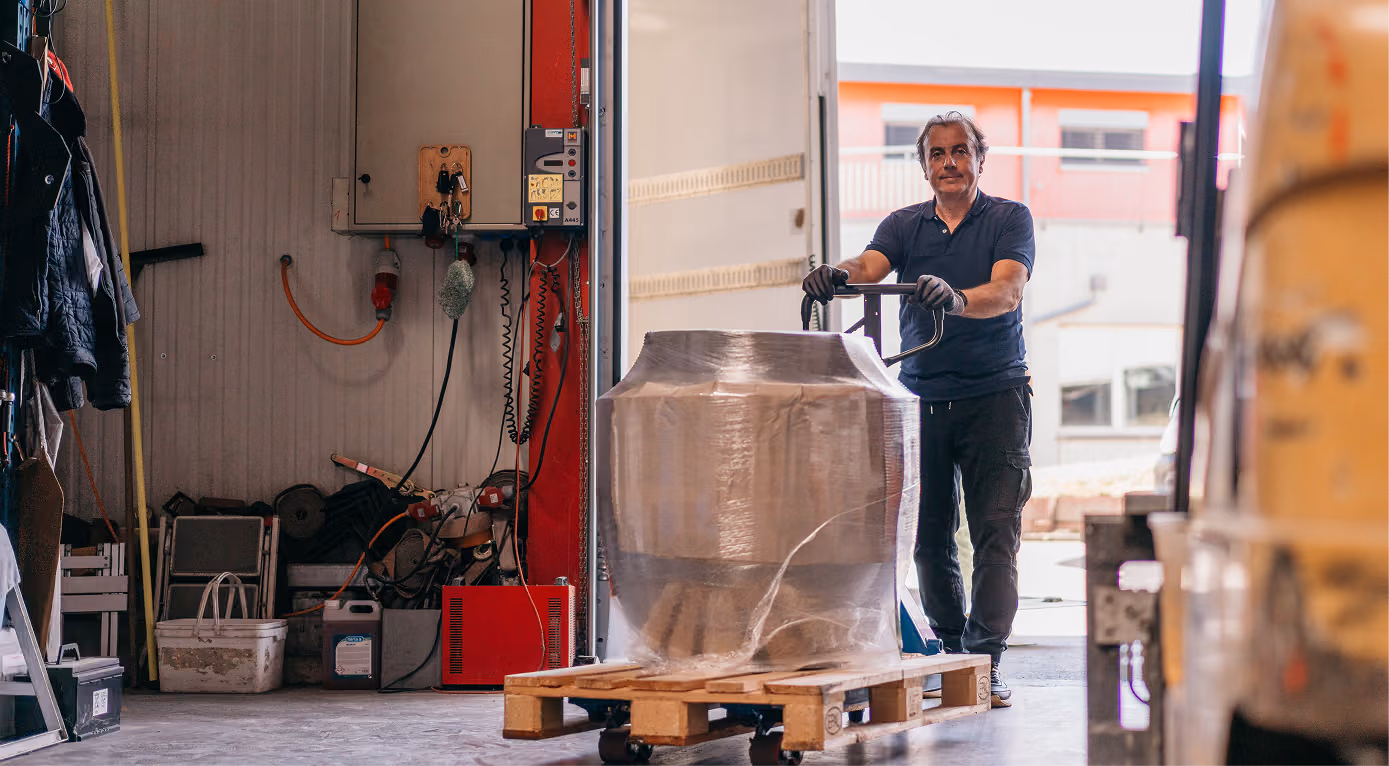 Roland Koch Transporte Schweiz: Mitarbeiter bewegt verpackte Fracht auf Palette